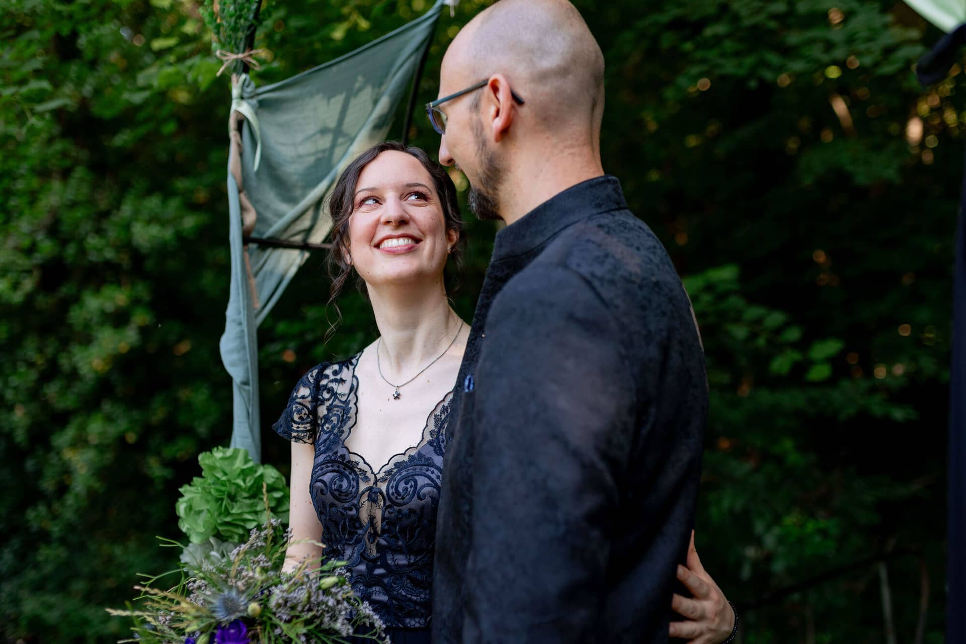 20250621 17 57 27 4K8A3819 Brautpaarshooting Felsenmuehle Neuleinigen.DhljouiP Liebevolles Brautpaar unter der grünen Laube