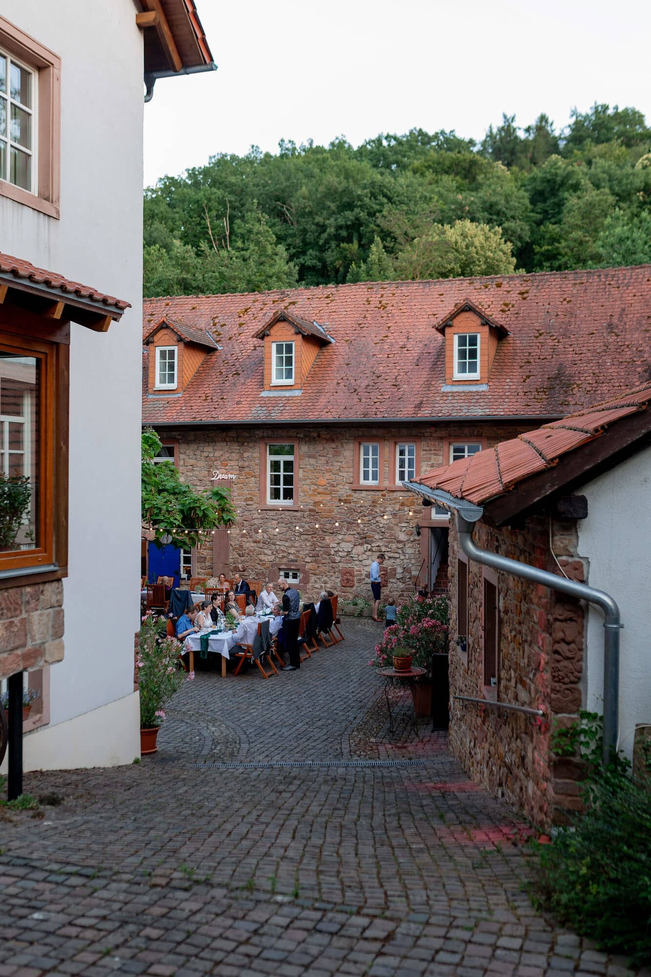 20250621 21 22 07 4K8A6014 Hochzeitsfeier Felsenmuehle Neuleinigen.B65V0Z2U Brautpaar unter magenta Beleuchtung beim Tanz