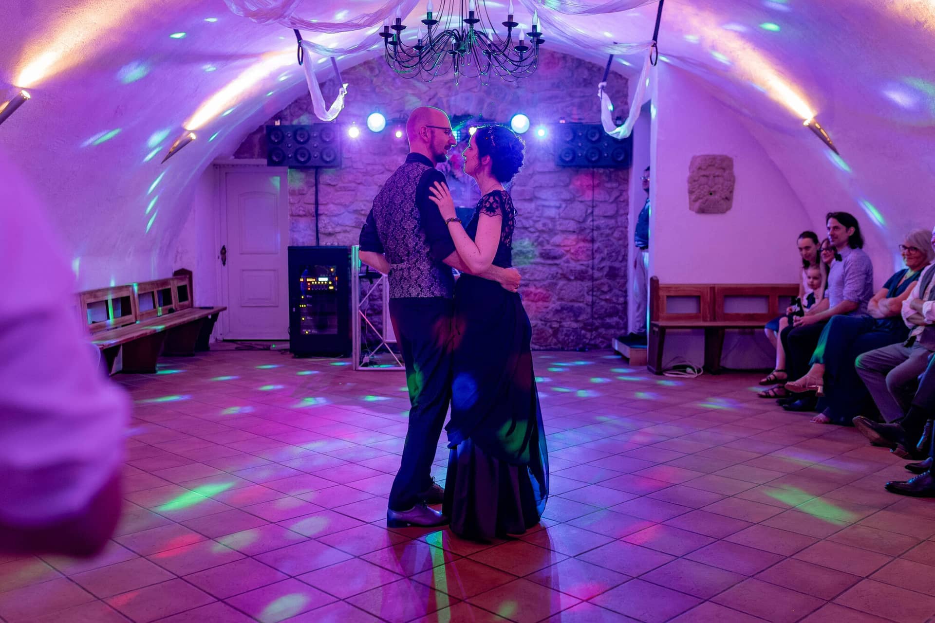 20250621 21 47 01 4K8A6255 Hochzeitsfeier Felsenmuehle Neuleinigen.CNRjJ1CW Lächelndes Brautpaar unter buntem Licht