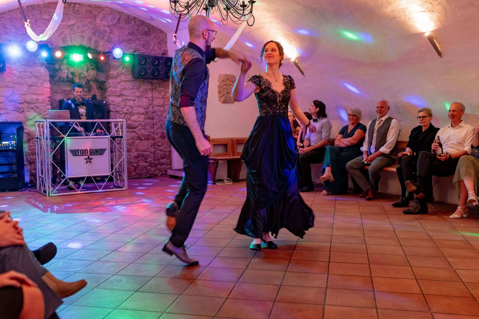 20250621 21 47 54 4K8A6346 Hochzeitsfeier Felsenmuehle Neuleinigen.CKpgN54p Brautpaar tanzt vor Gästen mit Partykeller-Beleuchtung