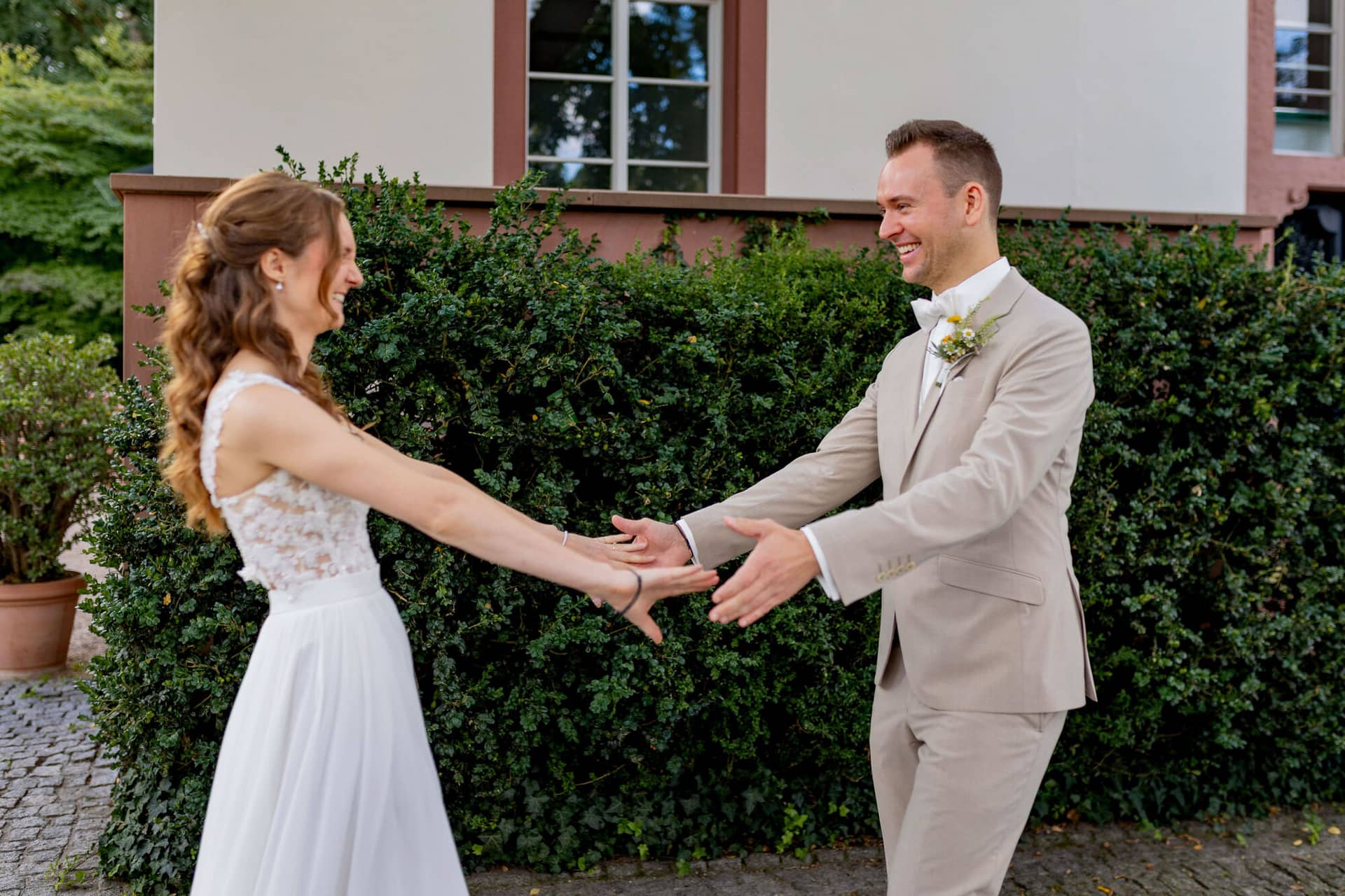 20250830 12 38 29 4K8A9784.Dw42dkcg Brautpaar hält sich an den Händen und lächelt sich beim First Look an