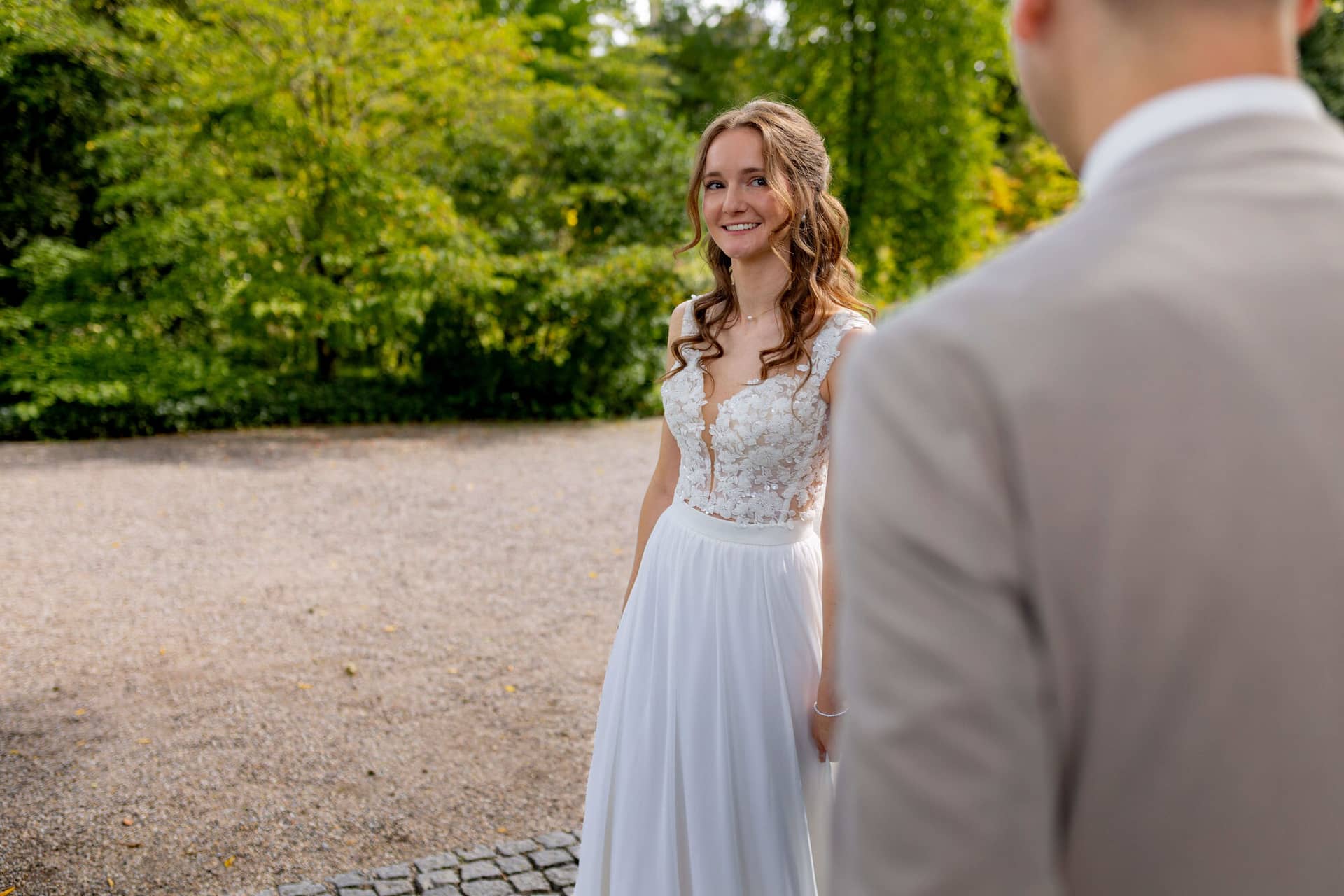 20250830 12 39 20 4K8A9854.DxF73D8R Braut lächelt den Bräutigam strahlend an im grünen Garten