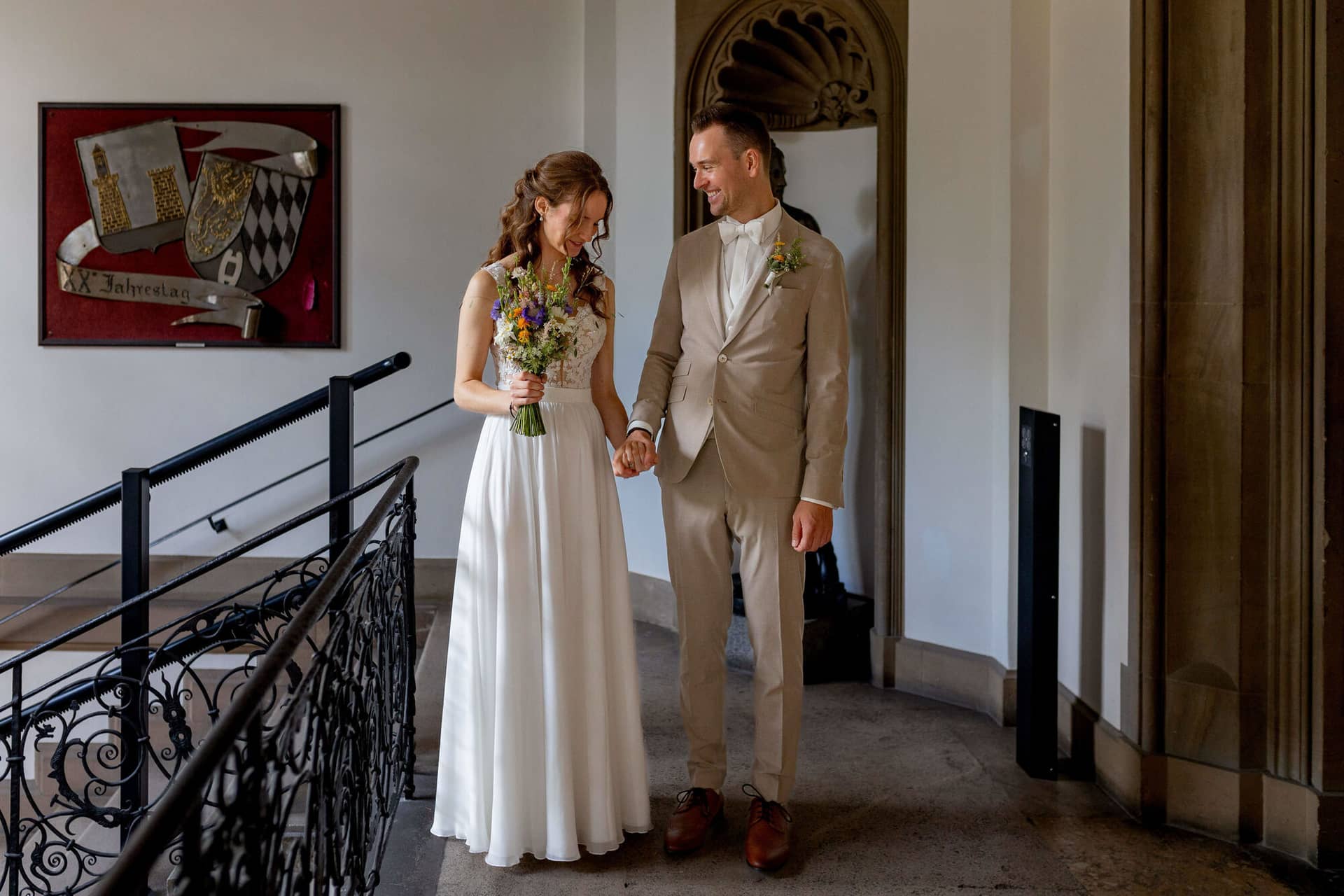 20250830 13 10 13 4K8A0011.DkZDLrm5 Brautpaar Hand in Hand im Flur des Standesamts Weinheim mit Brautstrauß