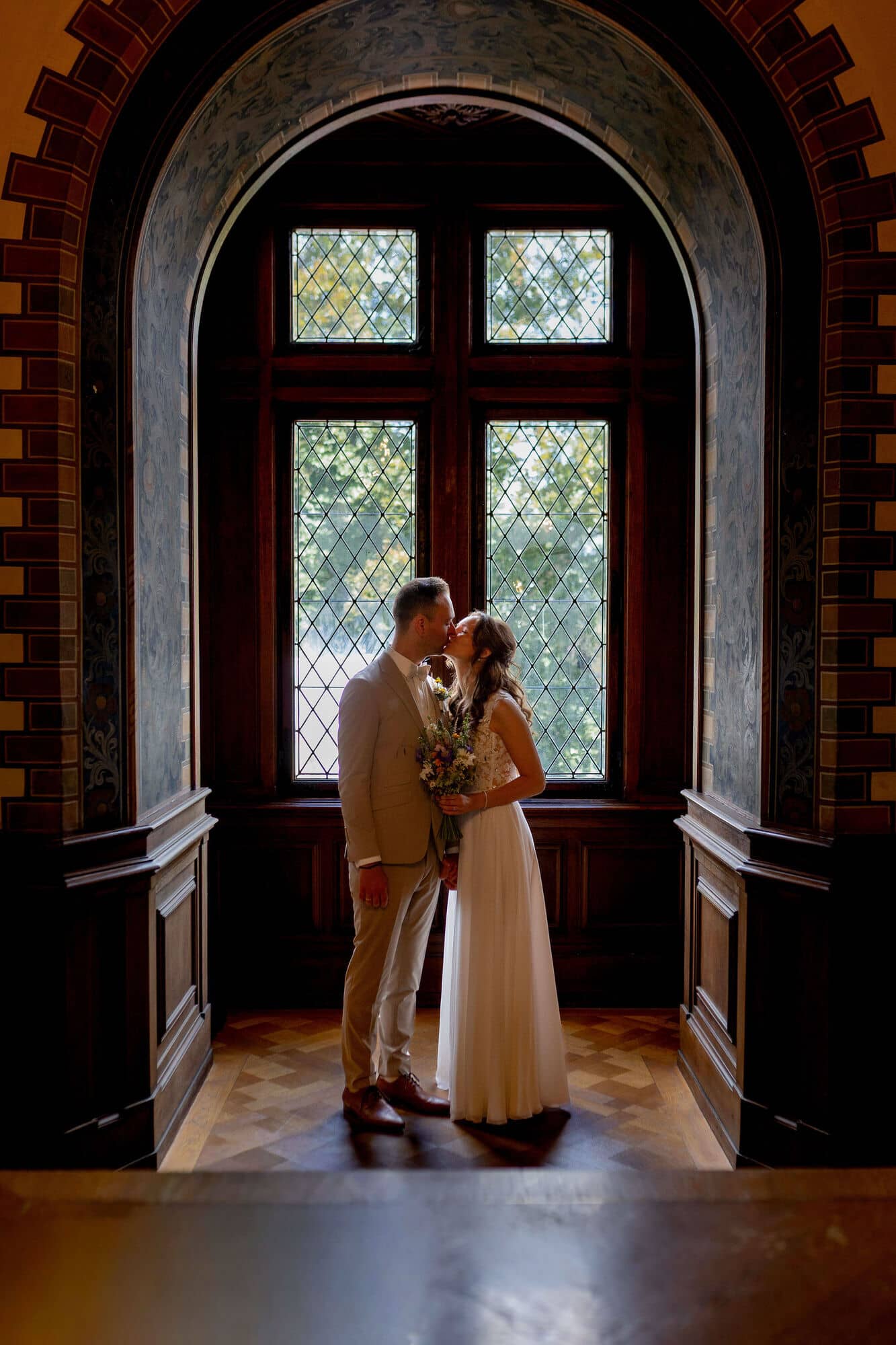 20250830 13 40 51 4K8A0565.ChmubgMy Brautpaar küsst sich vor dem Bogenfenster im Standesamt Weinheim