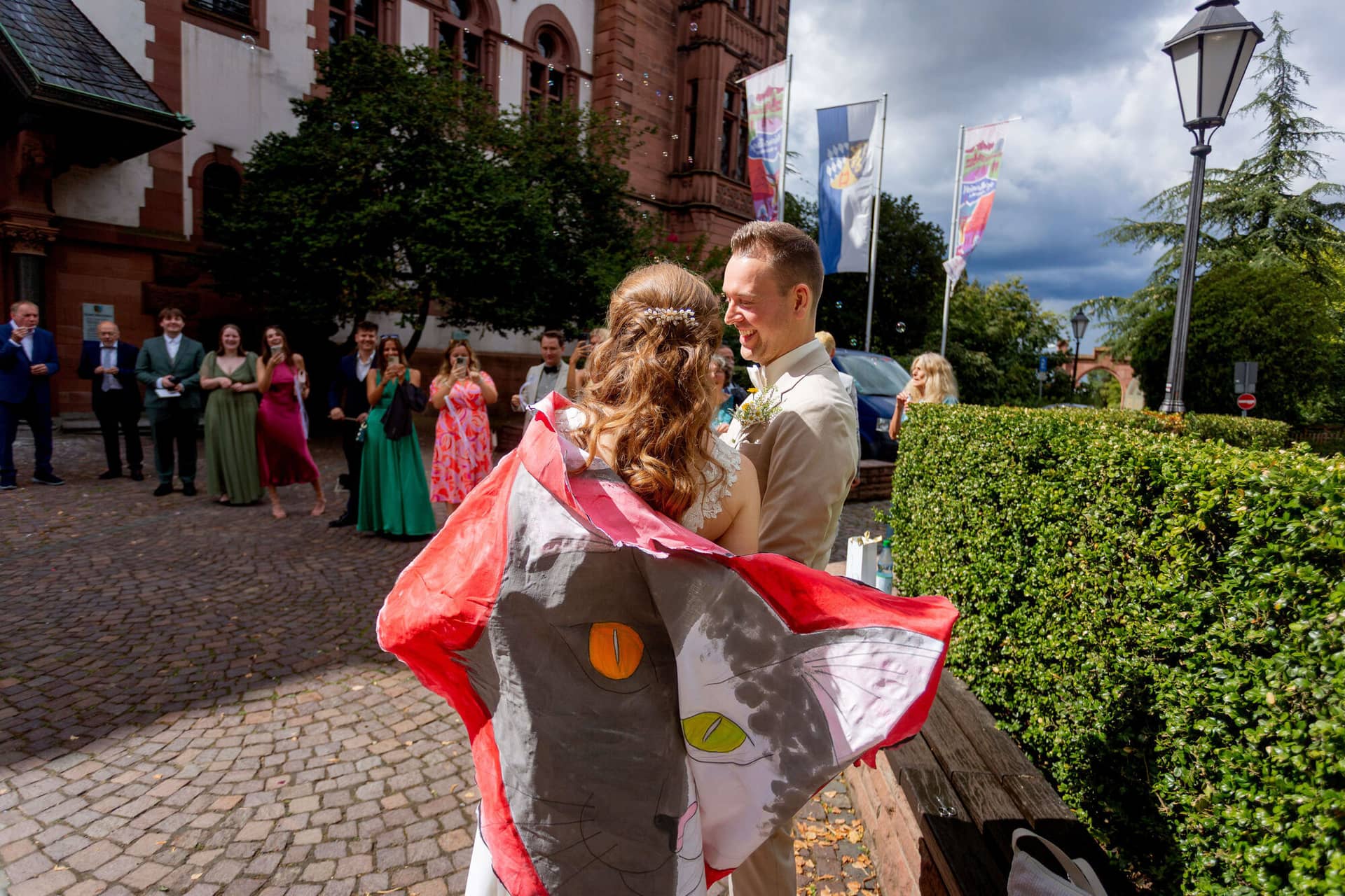 20250830 13 51 10 MK3 1056.ZjcGkswo Brautpaar umarmt sich nach dem Herz-Ausschneiden vor dem Standesamt