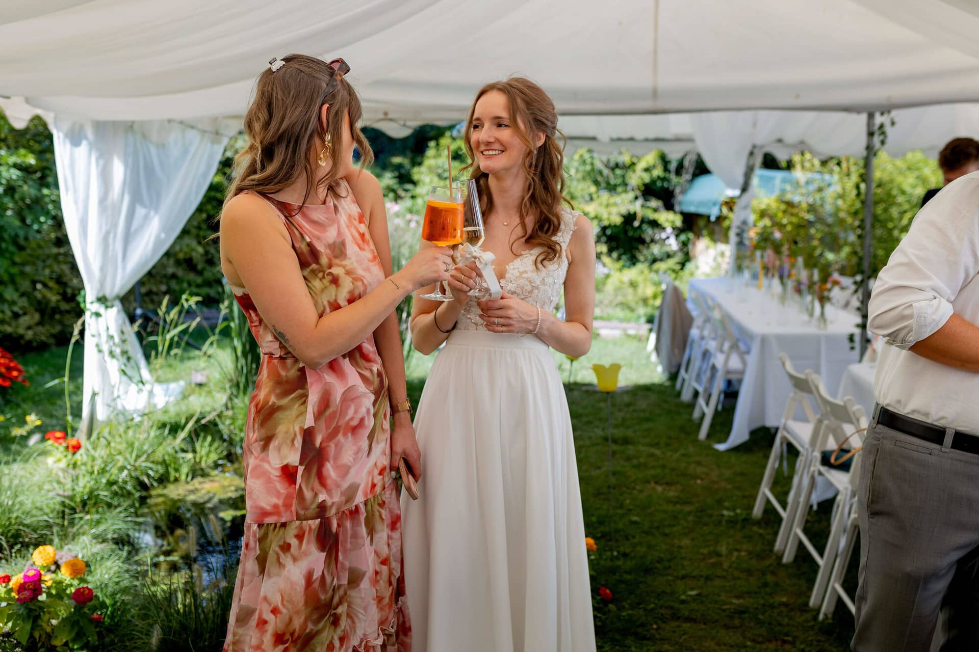 20250830 15 48 02 4K8A1827.XtZiJtUJ Braut stößt mit einer Freundin mit Cocktails im Garten an