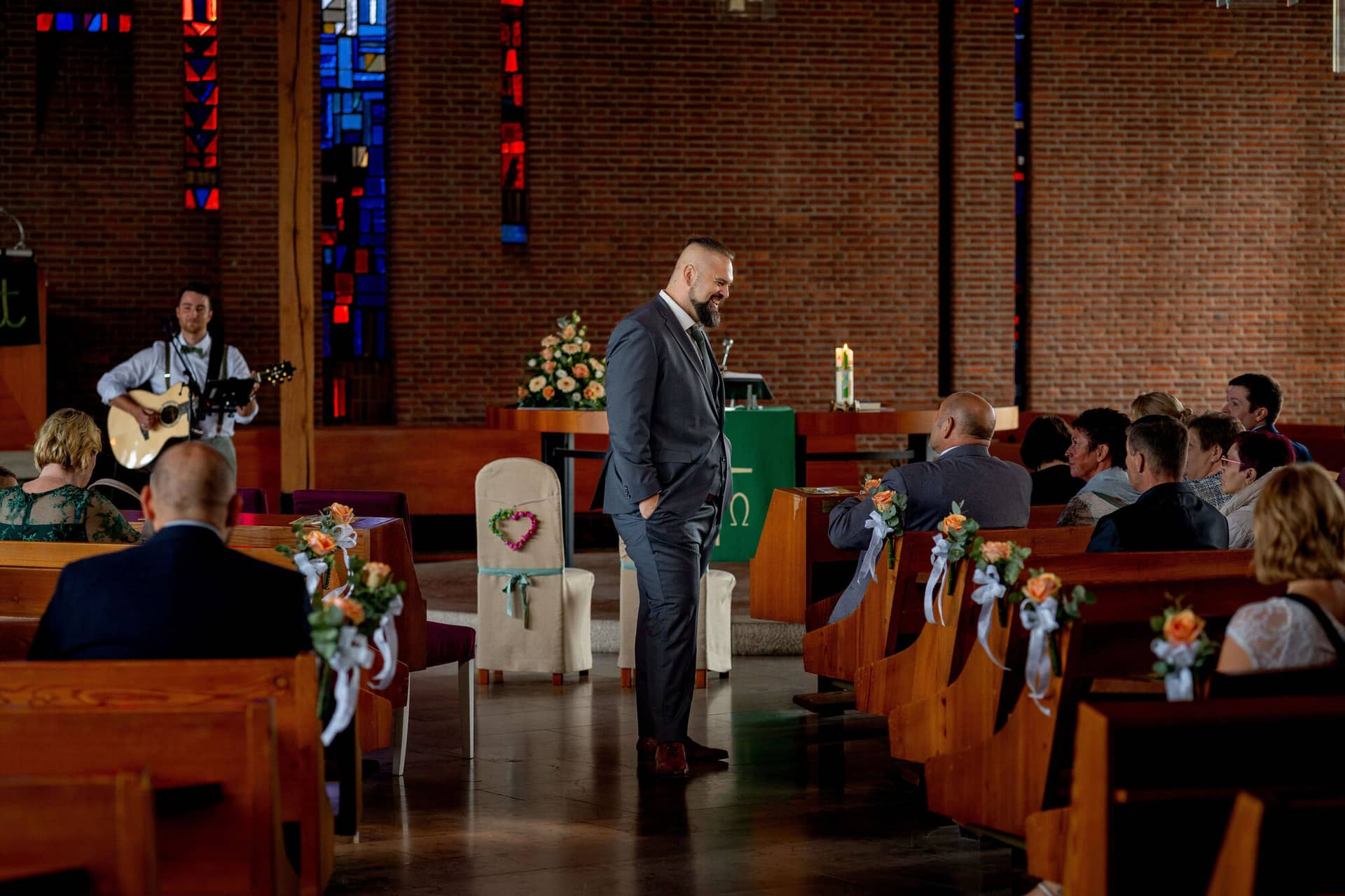 20250913 12 06 05 DSC04724.BbAocmCI Bräutigam steht am Altar während ein Gitarrist spielt