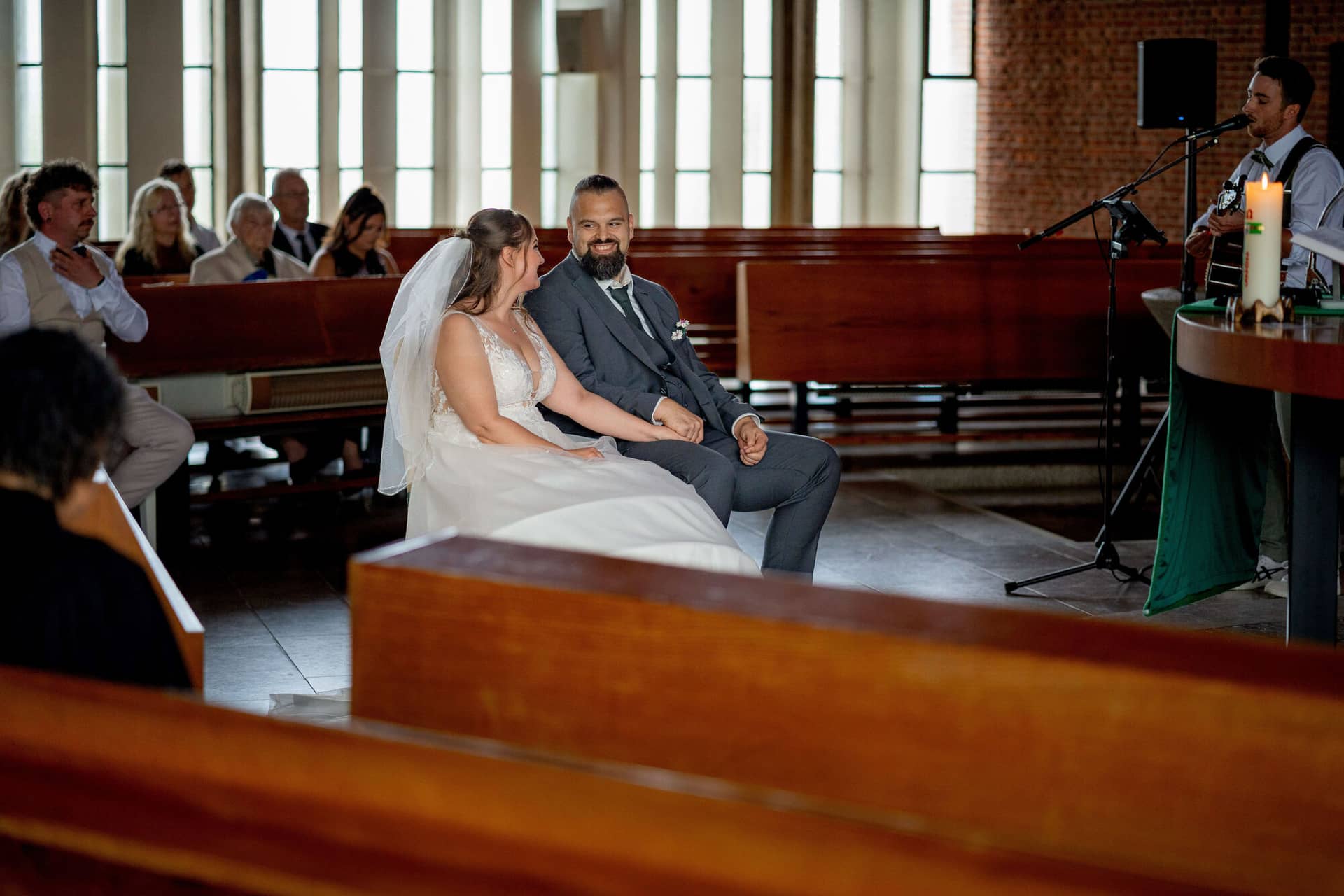 20250913 12 31 48 DSC05021.C4nrBhmX Brautpaar sitzt lächelnd nebeneinander während der Trauung