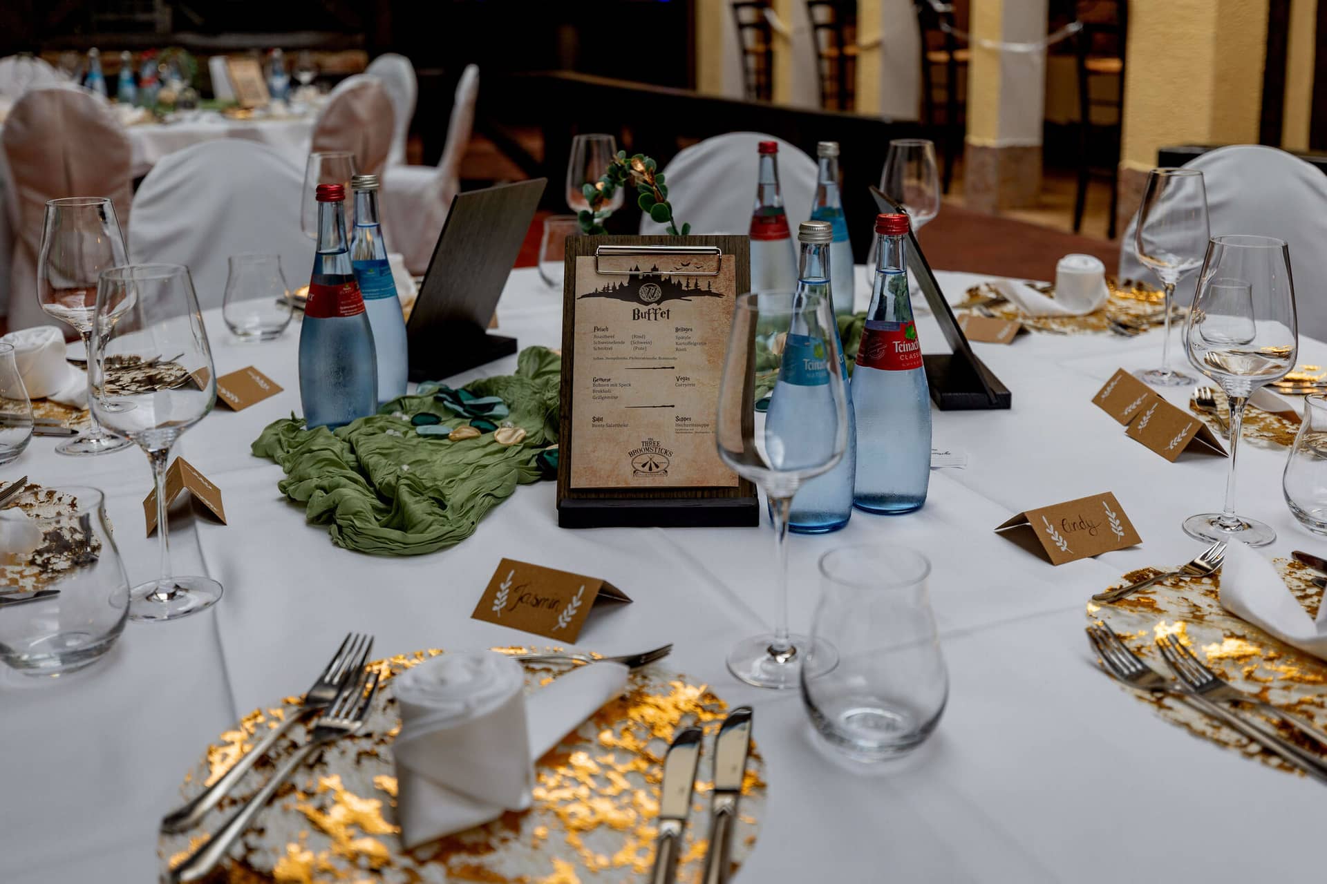 20250913 13 34 07 4K8A5586.INwaXfES Gedeckter Hochzeitstisch mit goldenen Platztellern und Buffet-Karte im Harry-Potter-Stil