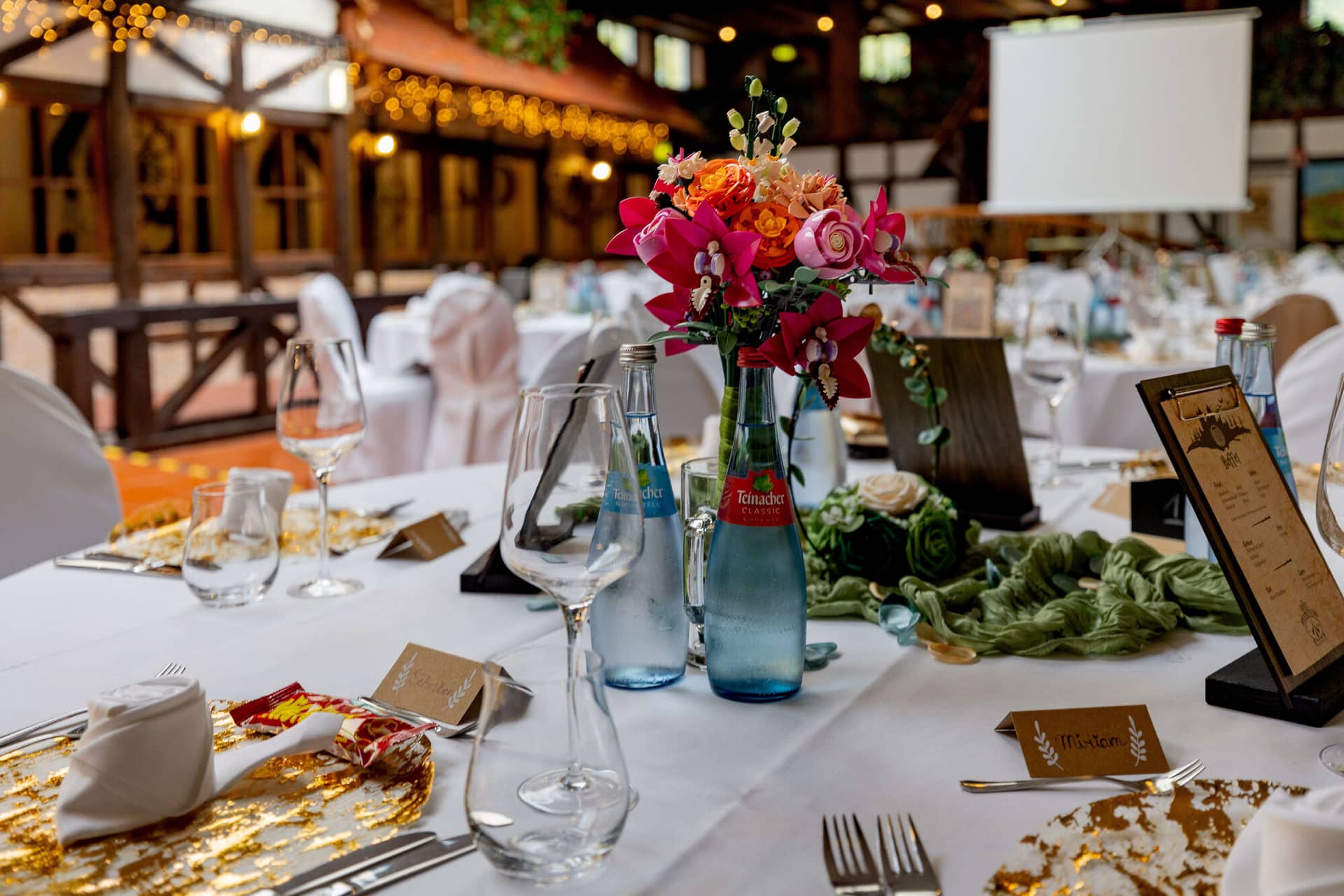 20250913 13 35 10 4K8A5602.BoW8KLTF Festlich gedeckte Tafel mit buntem Blumenstrauß und Fachwerk im Hintergrund