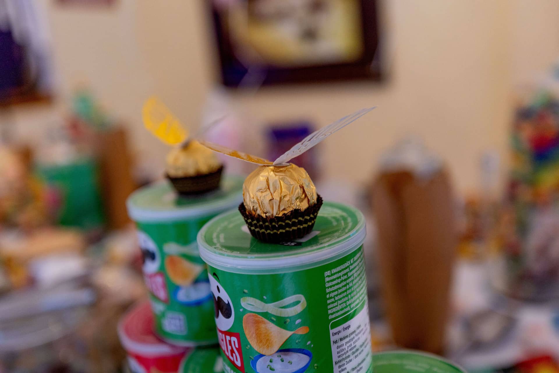 20250913 13 37 34 4K8A5630.BHMt5sja Goldener Schnatz aus Ferrero Rocher auf Pringles-Dose in Nahaufnahme