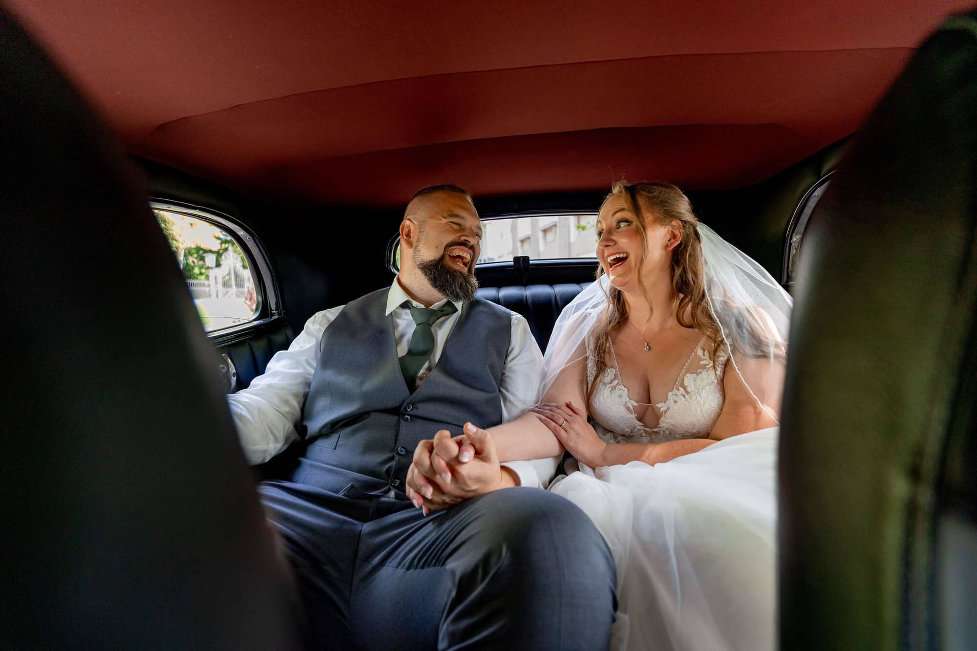 20250913 13 56 43 4K8A5759.KCpV3Pt Brautpaar lacht zusammen auf der Rückbank des Oldtimers