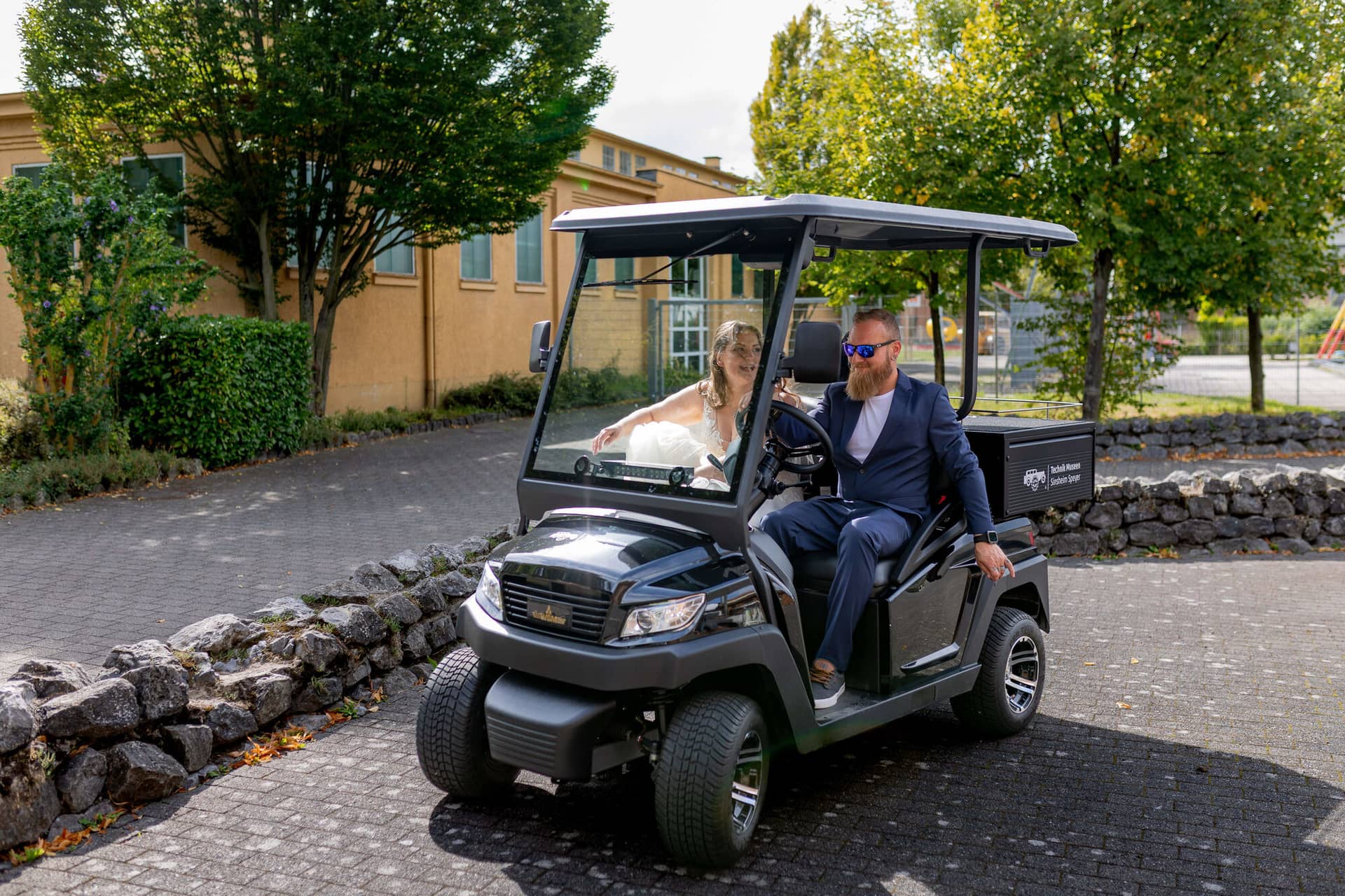 20250913 14 45 23 4K8A6257.CWJC4WNh Brautpaar fährt im Golfcart über das Museumsgelände
