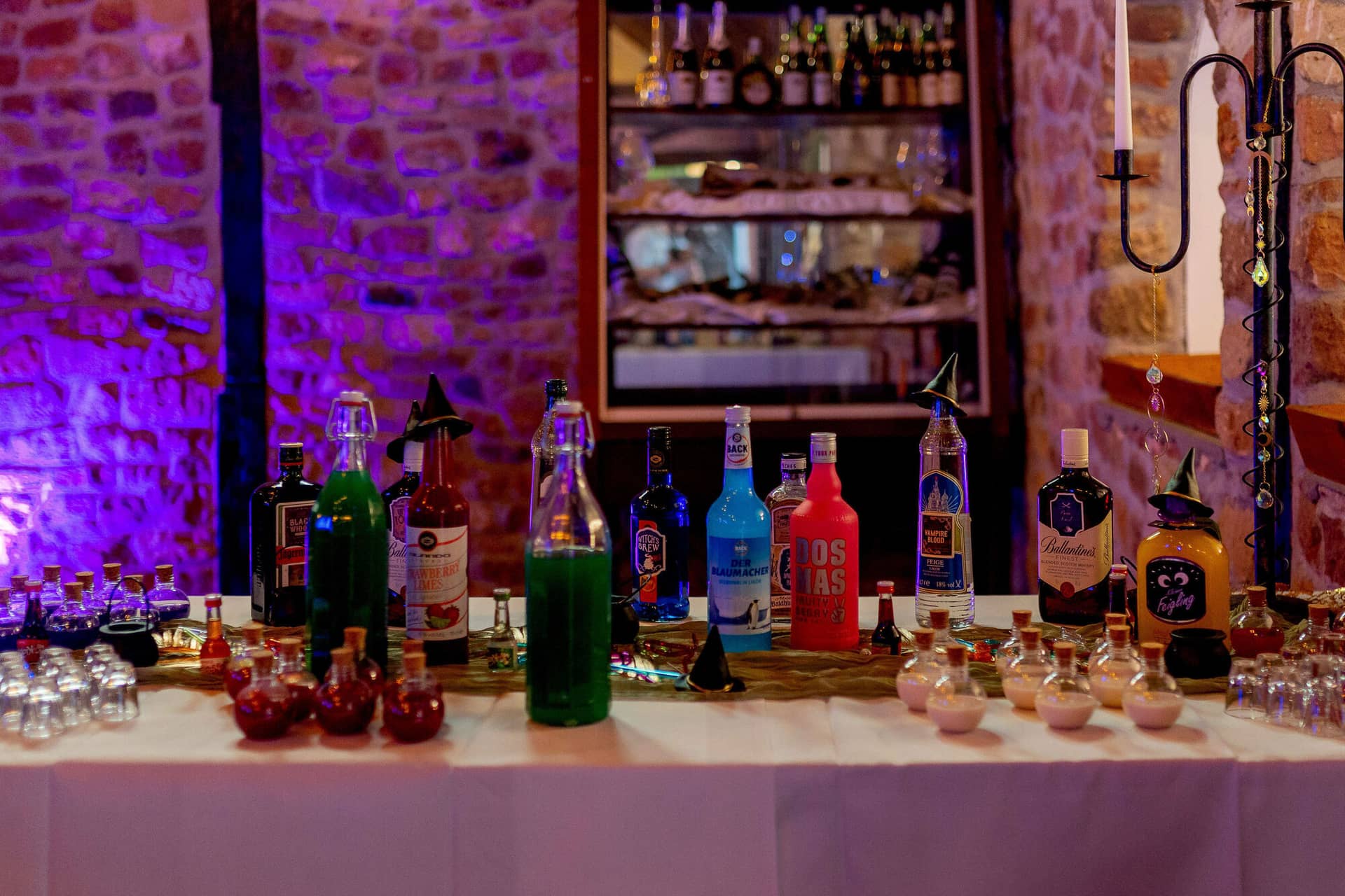 20250913 15 43 08 4K8A6849.BCdoB0Ga Zaubertrank-Bar mit bunten Flaschen und lila Beleuchtung