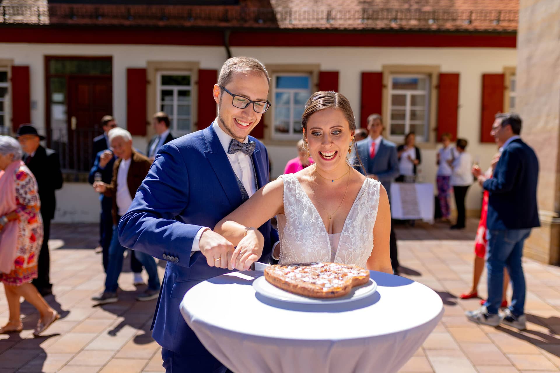 4K8A0068 Hochzeitsfotograf Mutterstadt Grenzhof Heidelberg .CIphElIS Brautpaar schneidet gemeinsam die Hochzeitstorte auf dem Innenhof des Grenzhofs in Heidelberg an