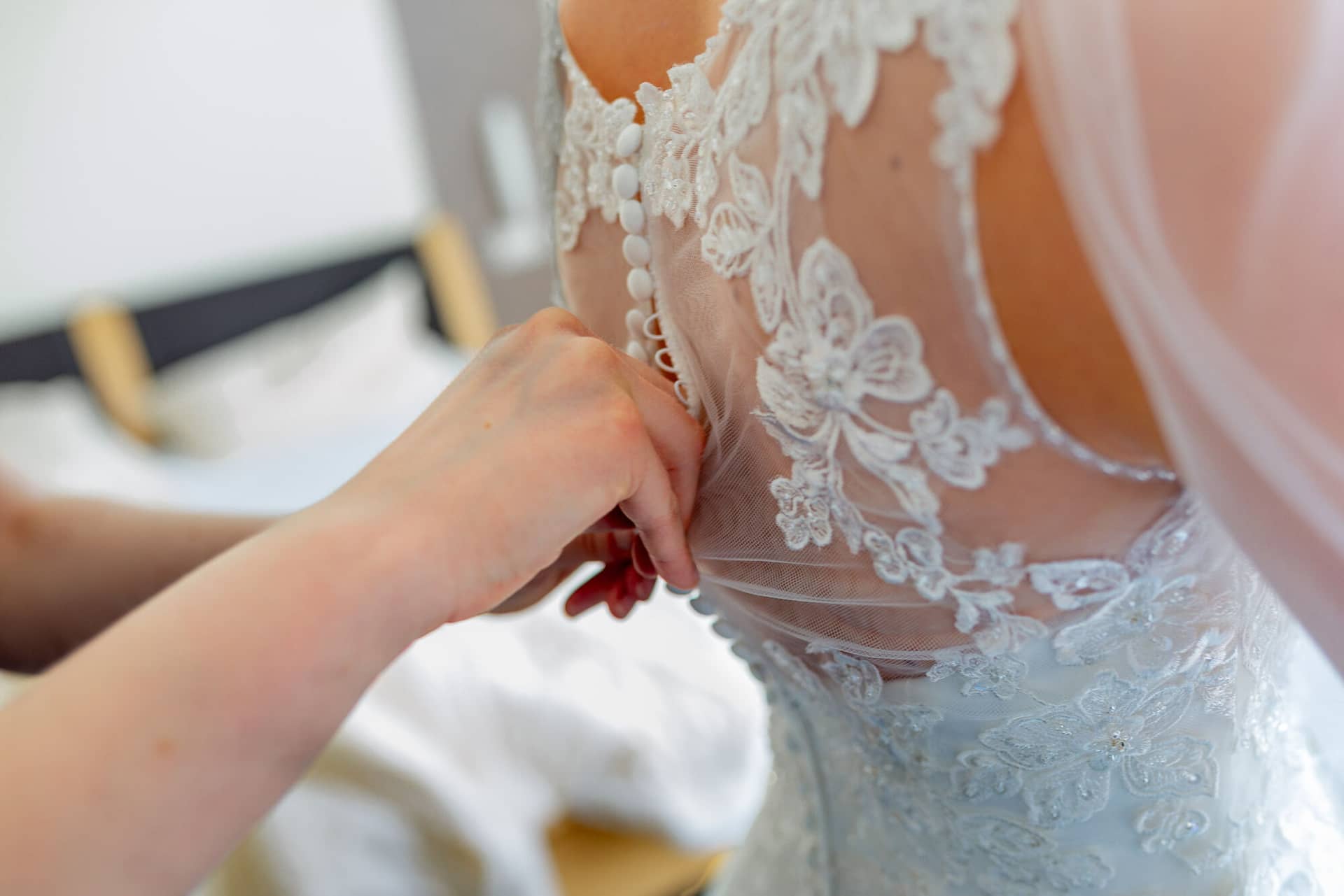 Anne Christian Hochzeitsfotograf Birkenheide Grosskarlbach Bissersheim 00003.C74nUkwk Hand justiert feines Spitze-Detail am Rücken des hochgeschlossenen weißen Brautkleides