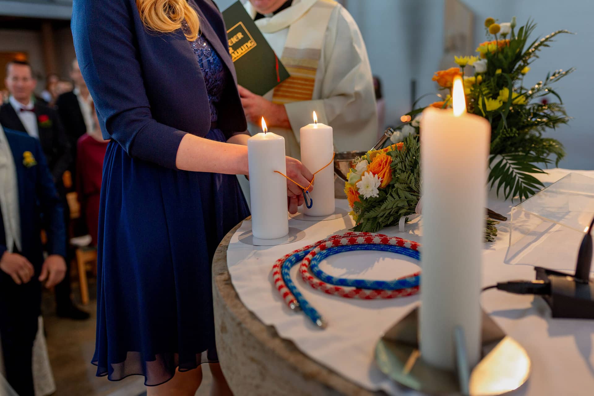 Anne Christian Hochzeitsfotograf Birkenheide Grosskarlbach Bissersheim 00011.ODfQ8Olw Braut hält feierlich einen Kerzenbinder in der Kirche, Bräutigam steht ihr aufmerksam zur Seite