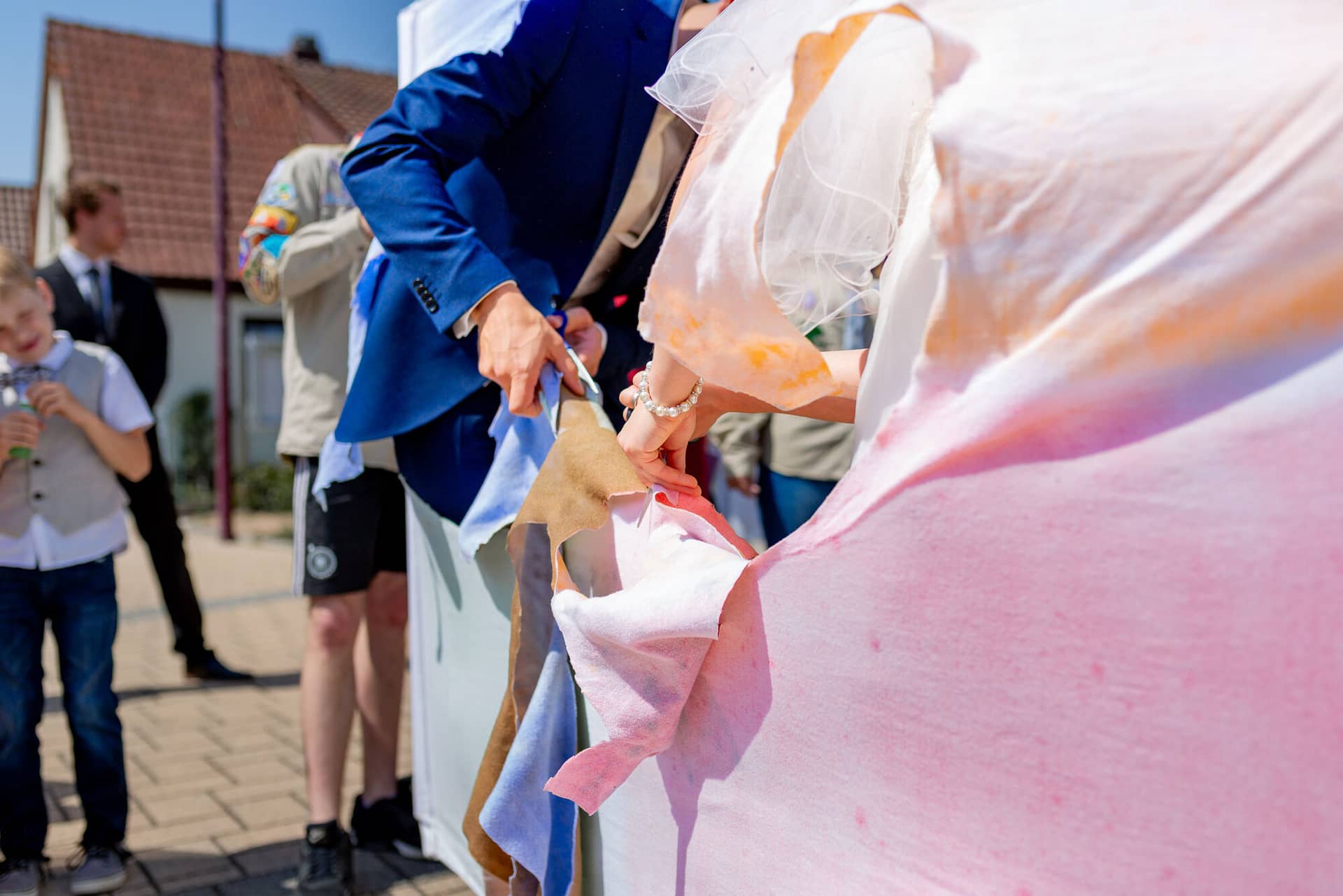 Anne Christian Hochzeitsfotograf Birkenheide Grosskarlbach Bissersheim 00016.CKbrhoIo Hochzeitsgast empfängt lachend ein Glücksbringer-Pechvögelchen von einem Mann im Anzug