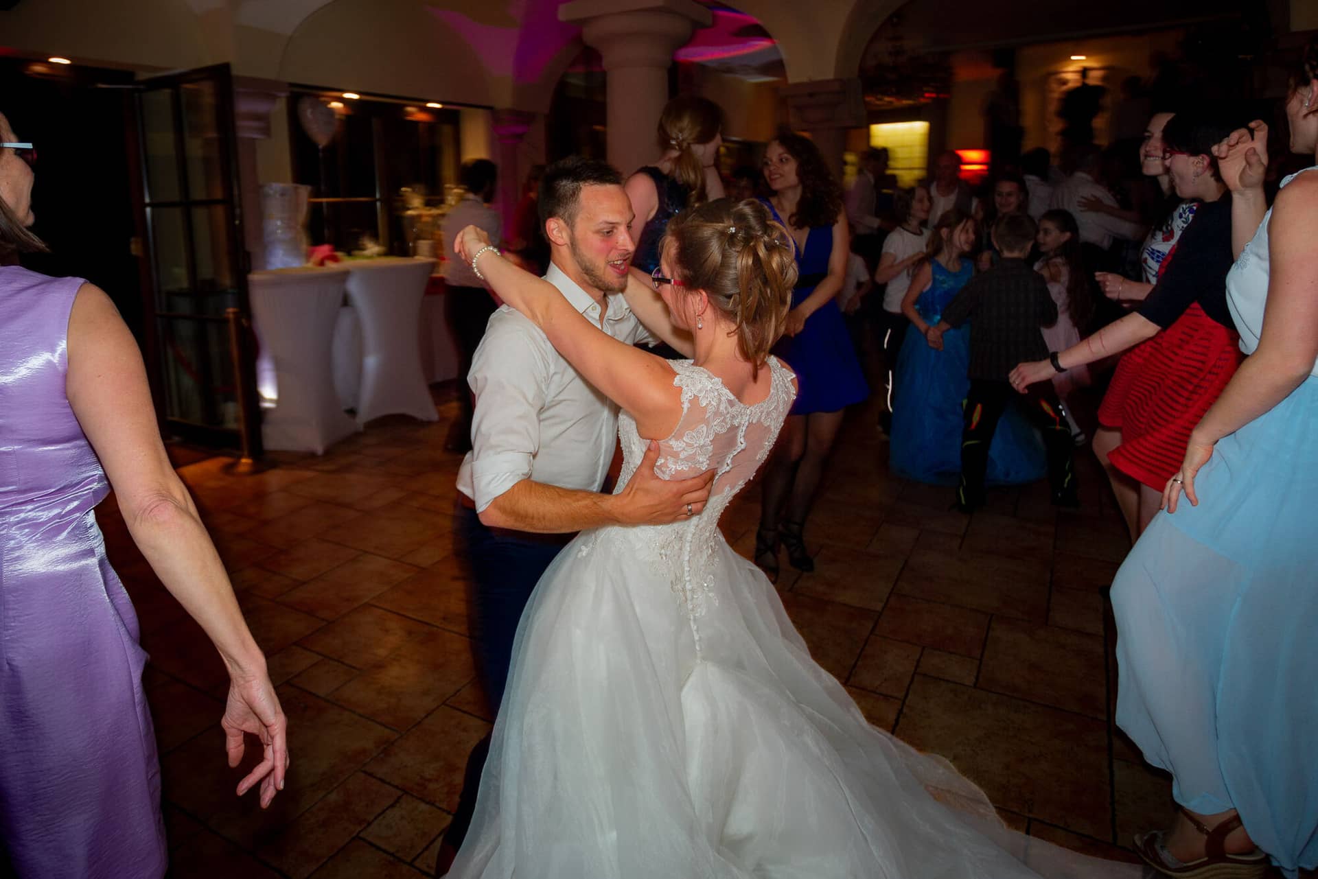 Anne Christian Hochzeitsfotograf Birkenheide Grosskarlbach Bissersheim 00043.BPrRyRwz Brautpaar tanzt ausgelassen mit Hochzeitsgästen auf dem belebten Hochzeitsballsaal