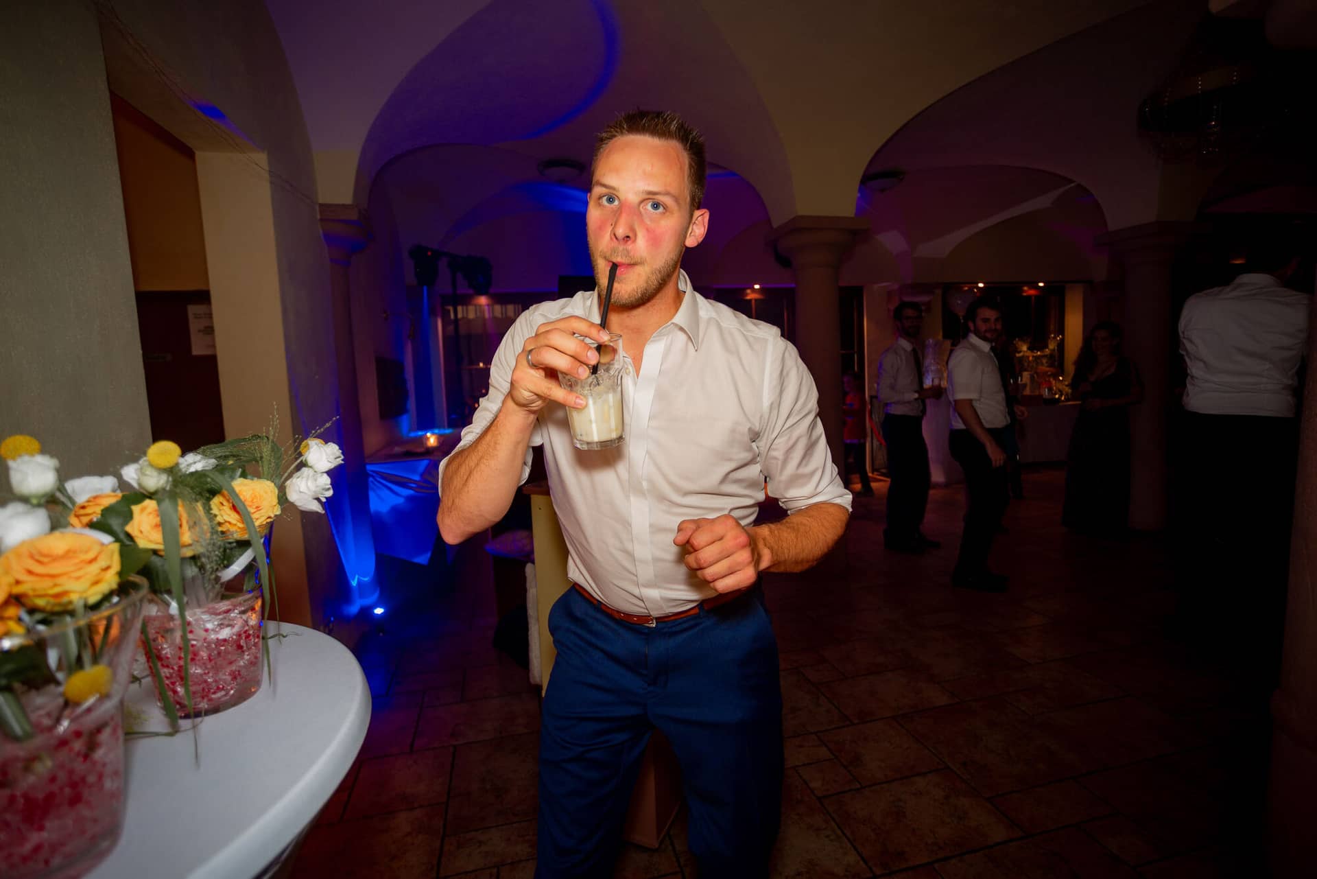 Anne Christian Hochzeitsfotograf Birkenheide Grosskarlbach Bissersheim 00044.D2hocqpv Junger Gast trinkt fröhlich einen Cocktail beim Feiern auf der Hochzeitsparty