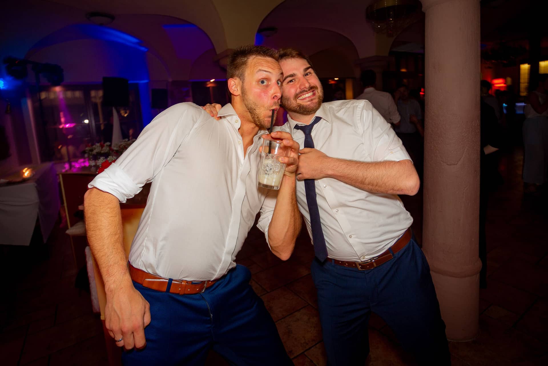 Anne Christian Hochzeitsfotograf Birkenheide Grosskarlbach Bissersheim 00045.CkTuQTV9 Zwei Freunde tanzen ausgelassen auf der Tanzfläche, einer hält ein Getränk in der Hand