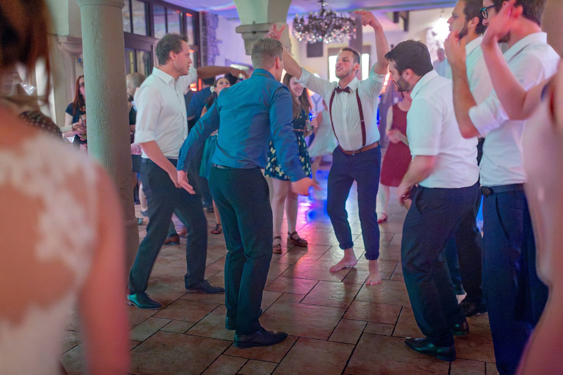 Anne Christian Hochzeitsfotograf Birkenheide Grosskarlbach Bissersheim 00050.DQEiQeQY Paare tanzen ausgelassen auf der festlichen Hochzeitstanzfläche mit Kronleuchter im Hintergrund