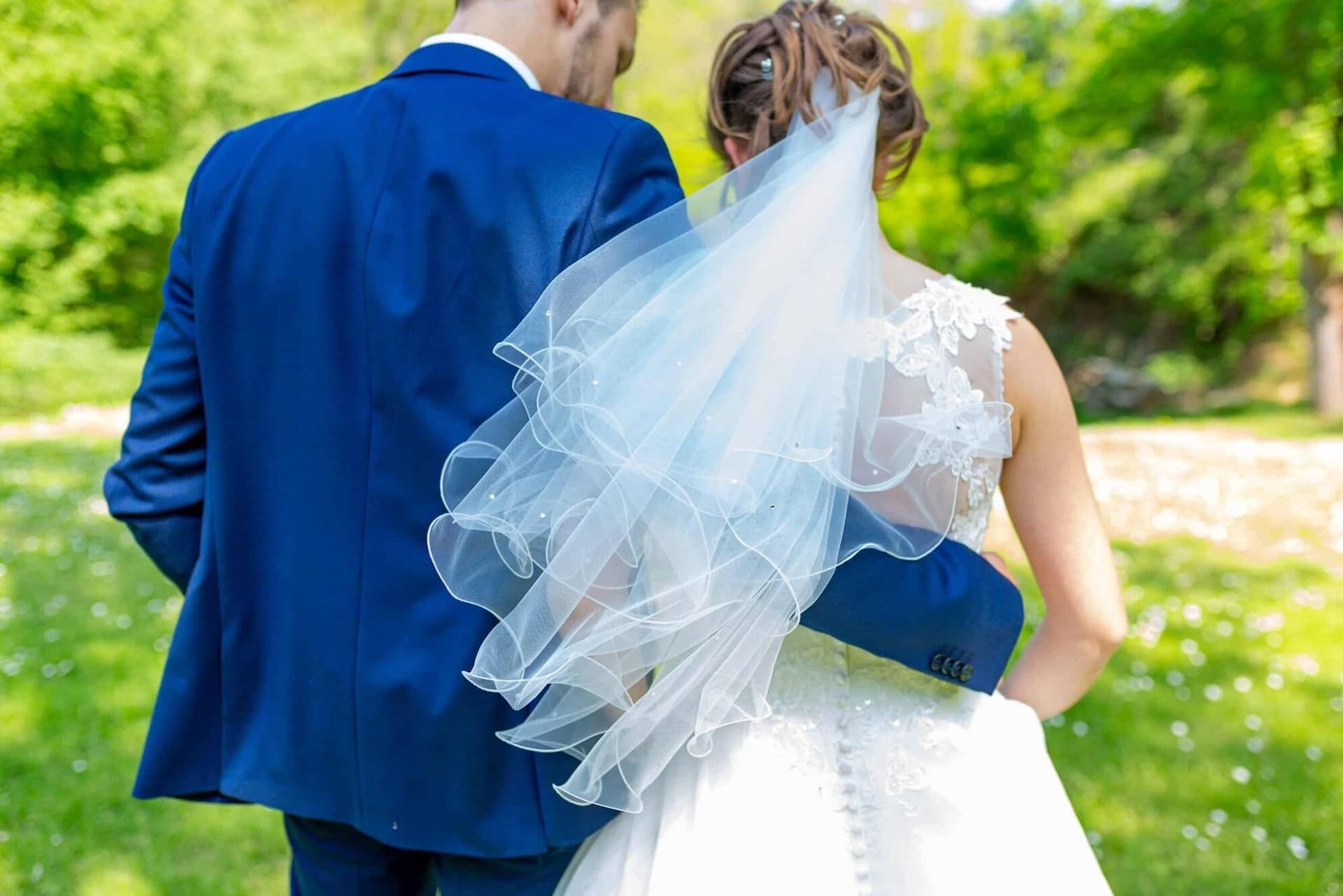 Anne Christian Hochzeitsfotograf Birkenheide Grosskarlbach Bissersheim 11.Y83iexyD Brautpaar im Grünen, Braut mit Schleier und Bräutigam im blauen Jackett schauen sich an