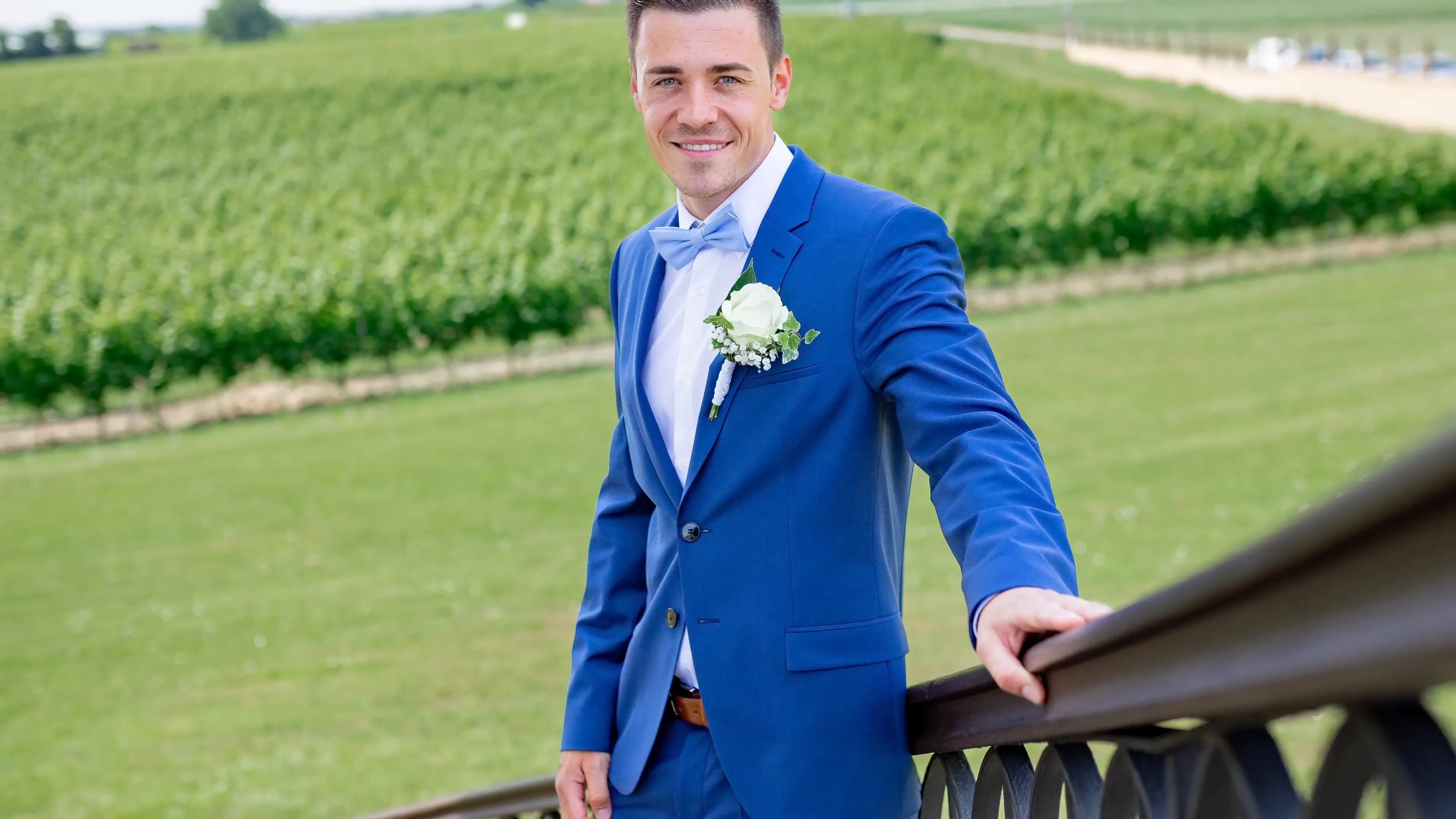 Bräutigam in einfachem blauen Anzug mit Fliege