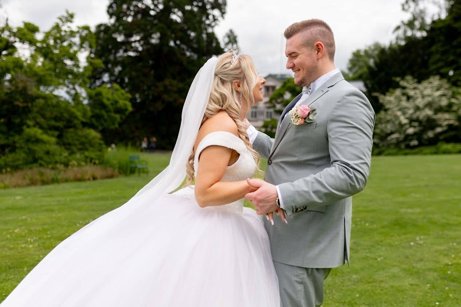 Brautpaarshooting Weinheim Schlossgarten Heidelberg Freie Trauung 4K8A5448 F50641e4 1500.C4ph38zJ Brautpaar schaut sich verliebt an, elegante Villa und blühender Garten im Hintergrund