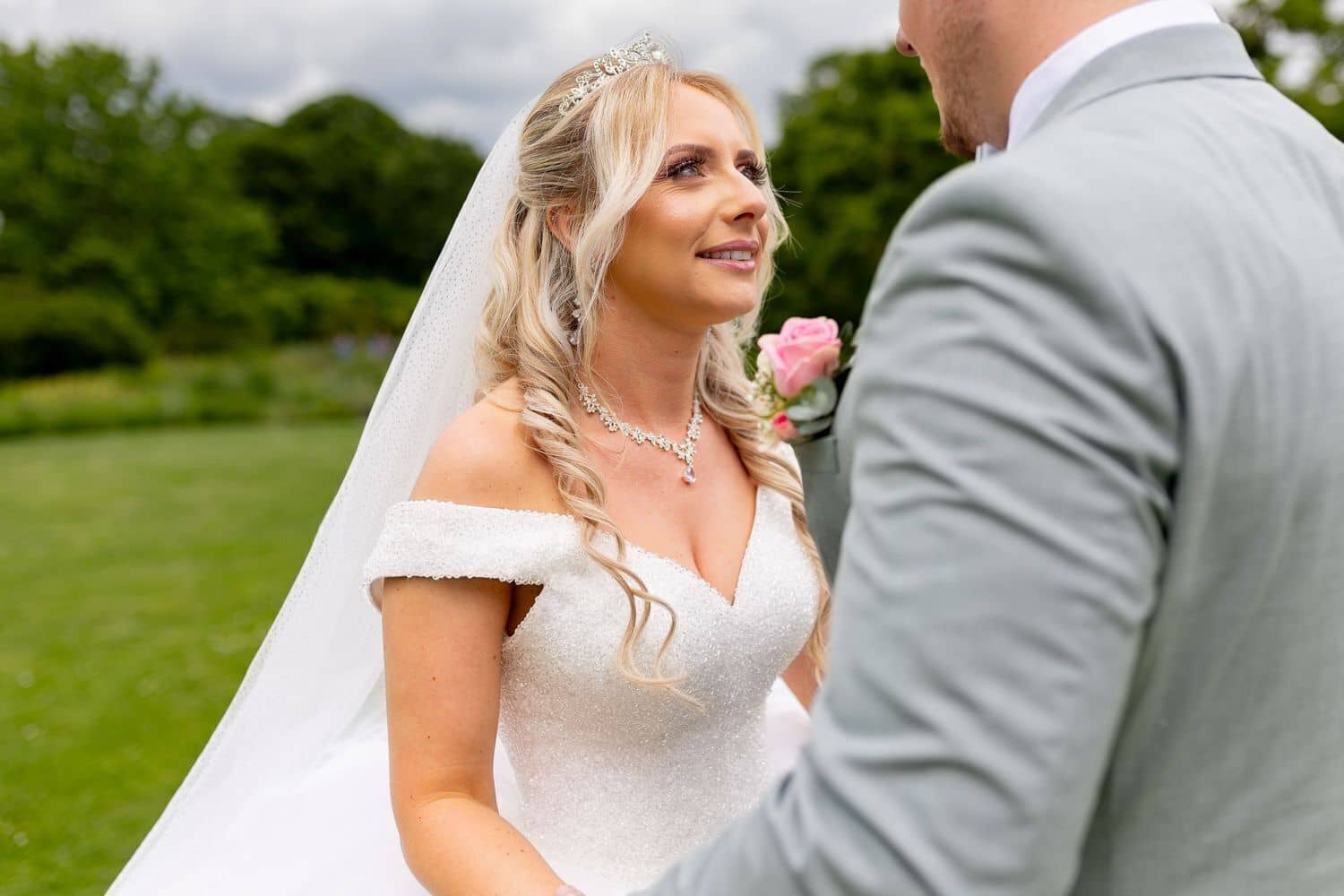 Brautpaarshooting Weinheim Schlossgarten Heidelberg Freie Trauung 4K8A5481 B0c05f60 1500.Cs4RVz9K Braut im glitzernden Brautkleid auf der Wiese, Bräutigam hält bewundernd eine einzelne rosa Rose