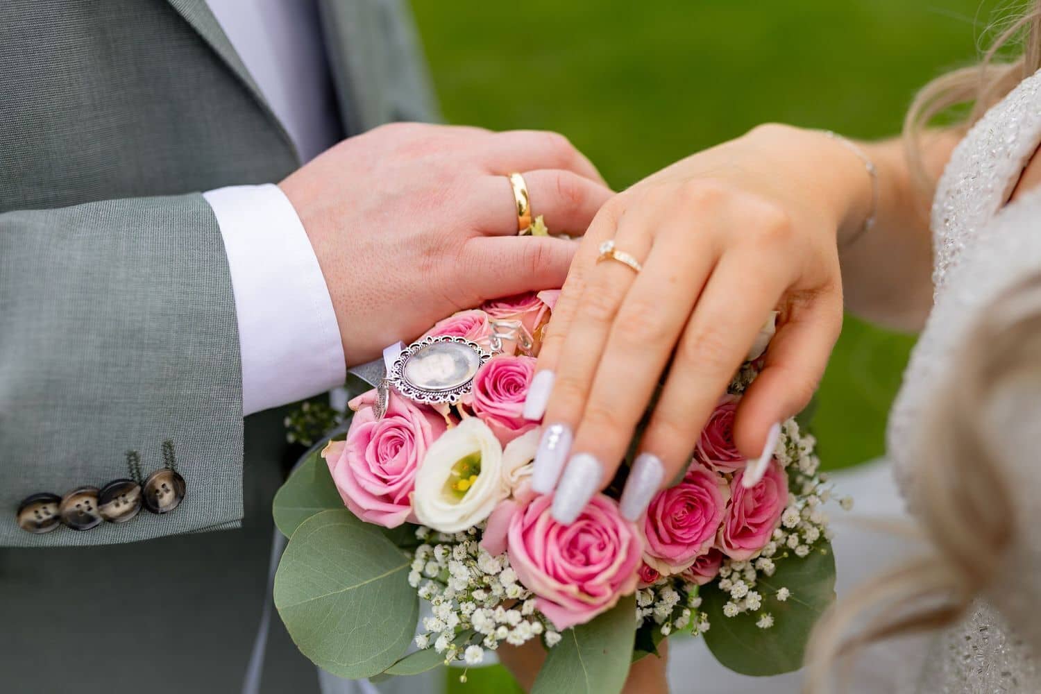 Brautpaarshooting Weinheim Schlossgarten Heidelberg Freie Trauung 4K8A5796 5ee39758 1500.DvV1sBso Nahaufnahme der verschränkten Hände des Brautpaares mit goldenen Eheringen und Blumenstrauß