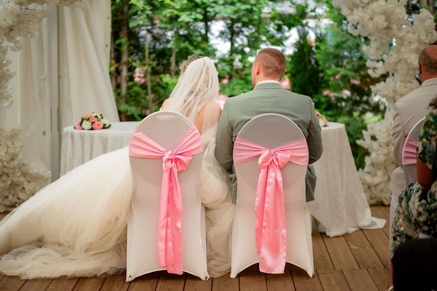 Brautpaarshooting Weinheim Schlossgarten Heidelberg Freie Trauung MK3 4742 929659e7 1500.9Lm9bSmN Hochzeitsgäste sitzen auf weißen Stühlen bei der Zeremonie, elegante Braut im Hintergrund am Altar