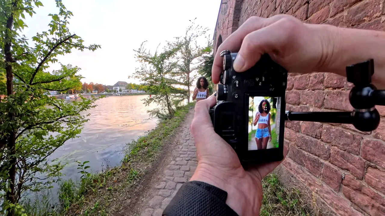 Fotograf prüft sichtbaren Fokuspunkt auf dem Kameradisplay während Model im Bild steht