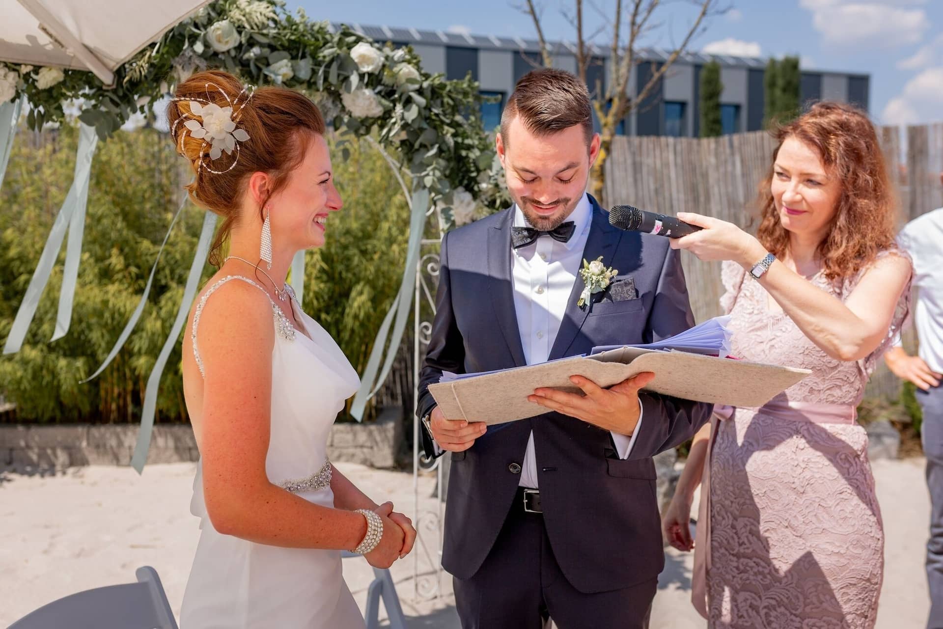 Hochzeit Schwetzingen Hochzeitsfotograf Heiraten Miio MK3 7419.BZOdD3o6 Brautpaar vor dem Blumenaltar während die Traurednerin den Text der freien Trauung vorliest