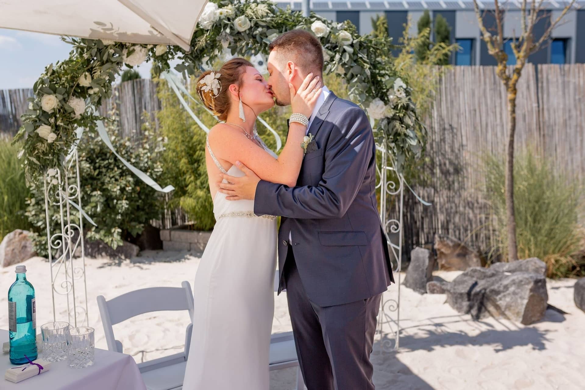 Hochzeit Schwetzingen Hochzeitsfotograf Heiraten Miio MK3 7494.CnfNbFfs Der erste Kuss als Ehepaar: Brautpaar küsst sich leidenschaftlich unter der Markise auf dem Sandstrand des Miio