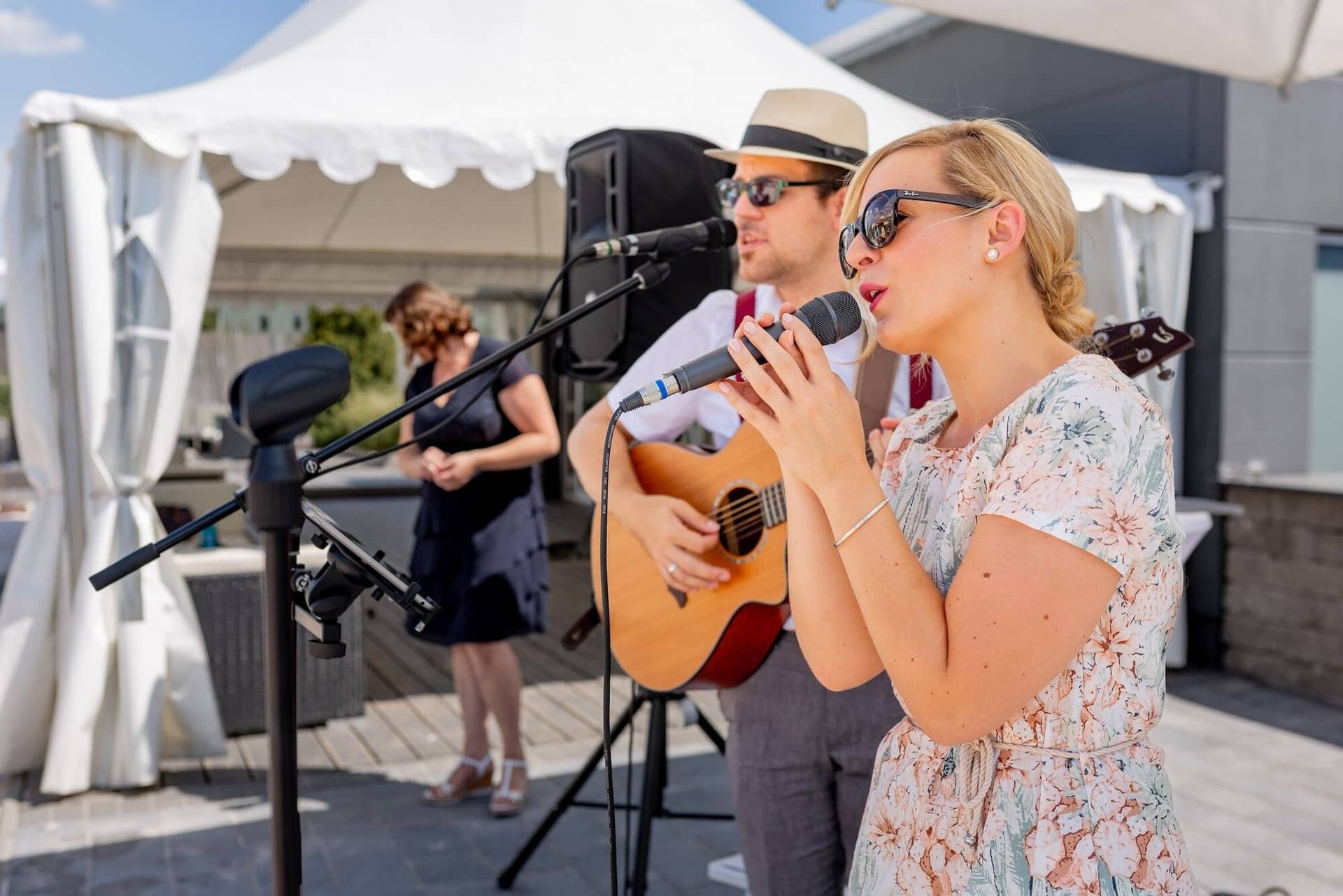 Hochzeit Schwetzingen Hochzeitsfotograf Heiraten Miio MK3 7542.OYARwToM Live-Band spielt beim Hochzeitsempfang, Sängerin mit Mikrofon und Gitarrist mit Strohhut und Brille