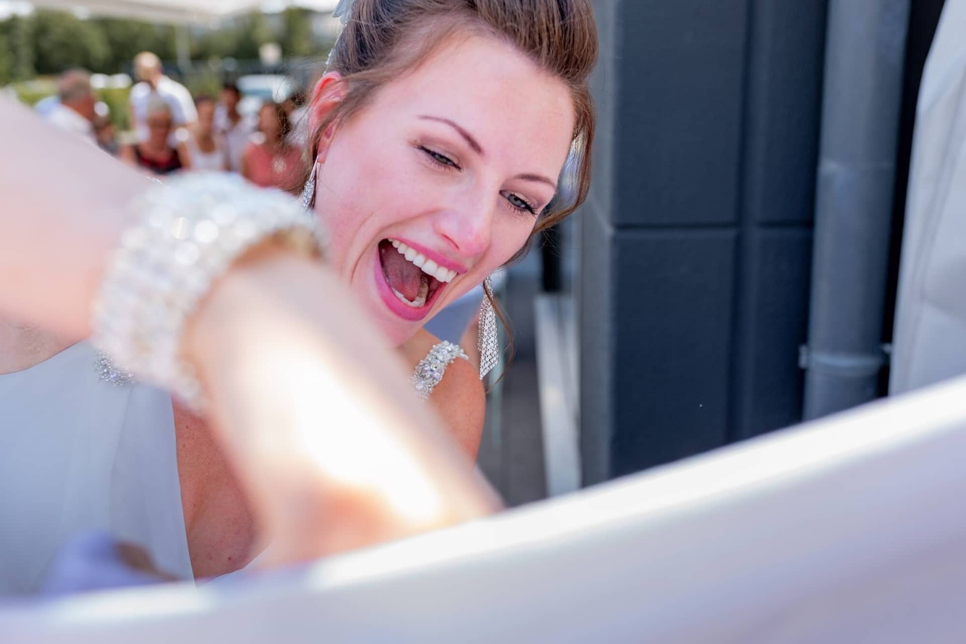 Hochzeit Schwetzingen Hochzeitsfotograf Heiraten Miio MK3 7984.BD7d3eq Bräutigam schreibt auf das große weiße Hochzeitsbanner, Braut schaut lächelnd durch einen Spiegel auf das Fest