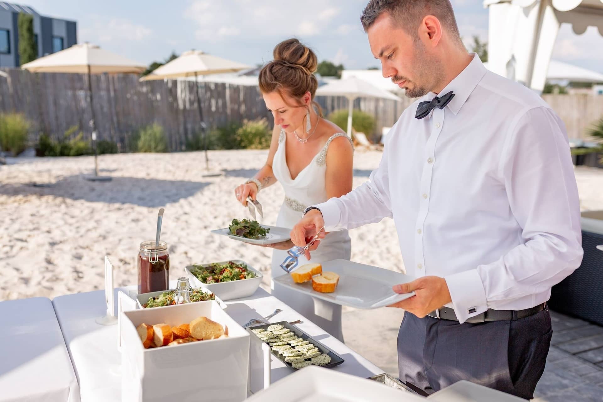 Hochzeit Schwetzingen Hochzeitsfotograf Heiraten Miio MK3 8486.DyOW5WAm Bräutigam serviert der Braut am Buffet auf dem Strand, entspannter Moment beim Empfang