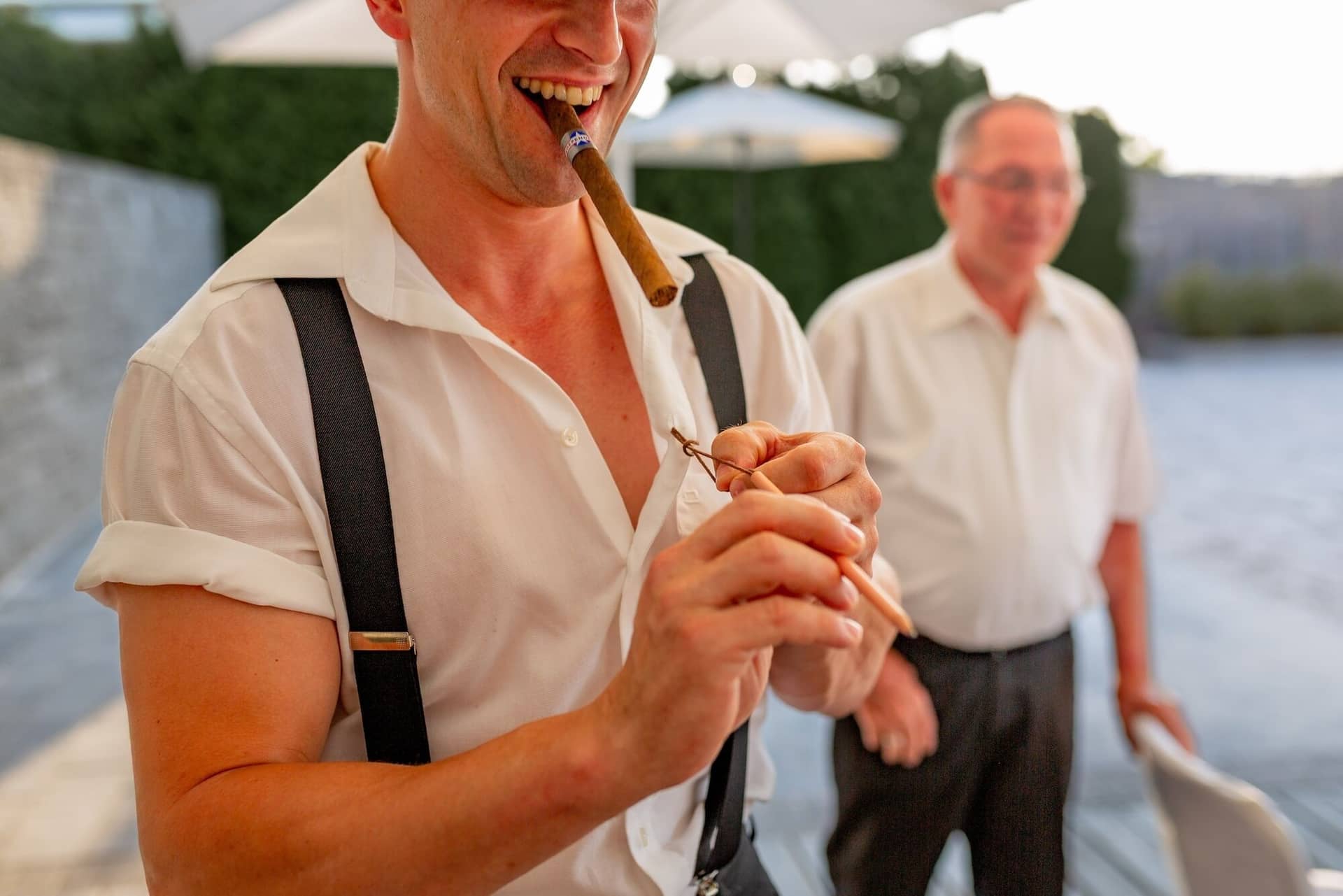 Hochzeit Schwetzingen Hochzeitsfotograf Heiraten Miio MK3 8572.B6T0l9h1 Gast genießt entspannt eine Zigarre bei der Hochzeitsfeier im Freien