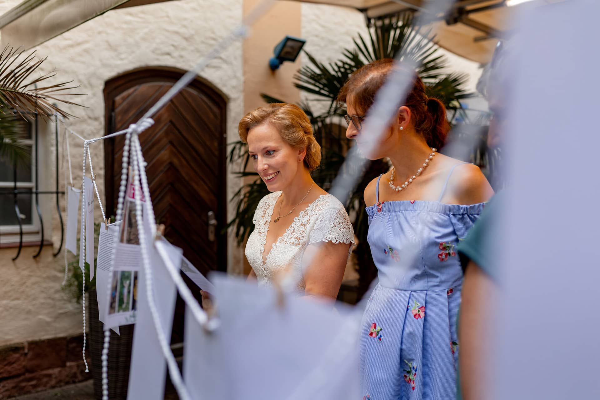 Hochzeitsfotograf Karlsruhe Daniela Matthias 20230819 18 14 06 4K8A9603.C 9DZhD2 Braut und Brautjungfer lächeln vor dem historischen Backsteinhaus der Majolika Manufaktur Karlsruhe