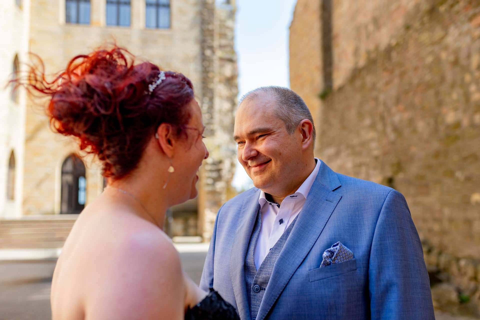 Hochzeitsfotograf Neustadt Hambacher Schloss Ruppertsberg Kellers Keller 14.DKqzBNgl Brautpaar lacht sich glücklich an während Wind durch rote Haare der Braut weht