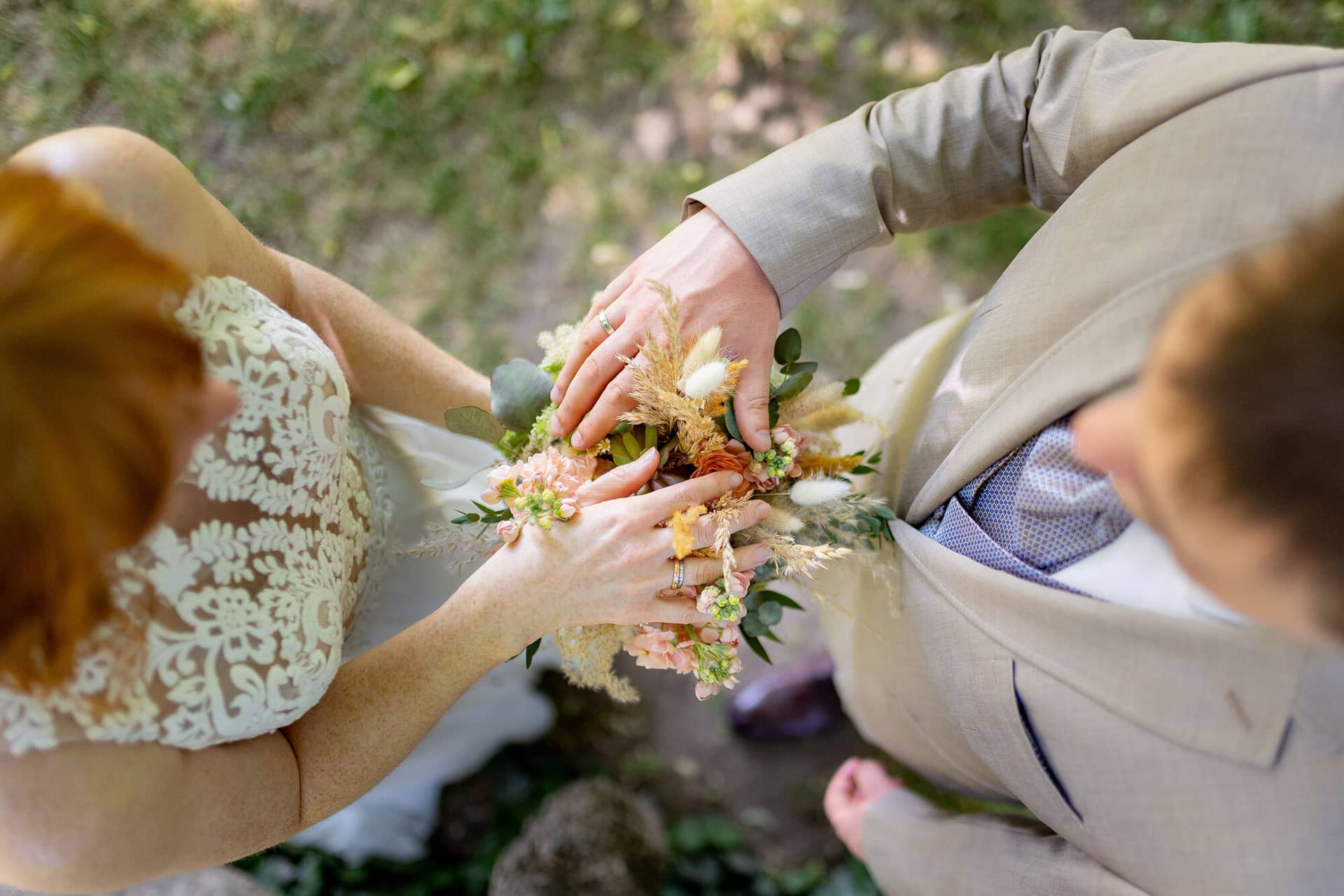 Hochzeitsfotograf Worms Frankenthal Hoftgut Petersau Brautpaarshooting 20230603 13 35 56 4K8A3300.DKWTjAxK Bräutigam steckt der Braut den Ring an den Finger im Schlossgarten Herrnsheim, Boho-Brautstrauß in der Hand