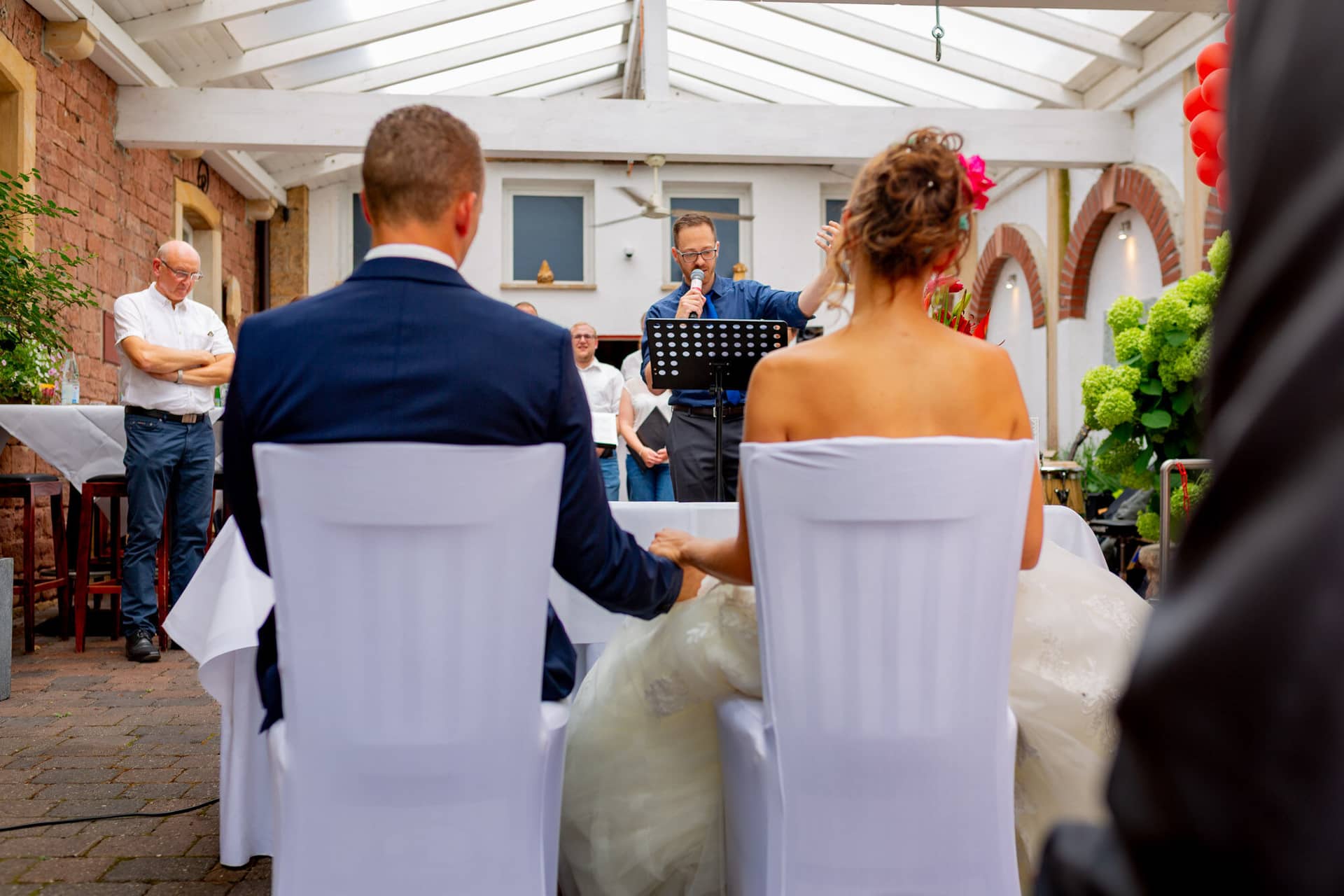 Jennifer Gregor Hochzeitsfotograf Rebe Deidesheim Feier 02 Eine Ehepaar Sitzt An Einem Tisch.C4 SIkLT Jennifer und Gregor beim Hochzeitsessen in der Rebe Deidesheim