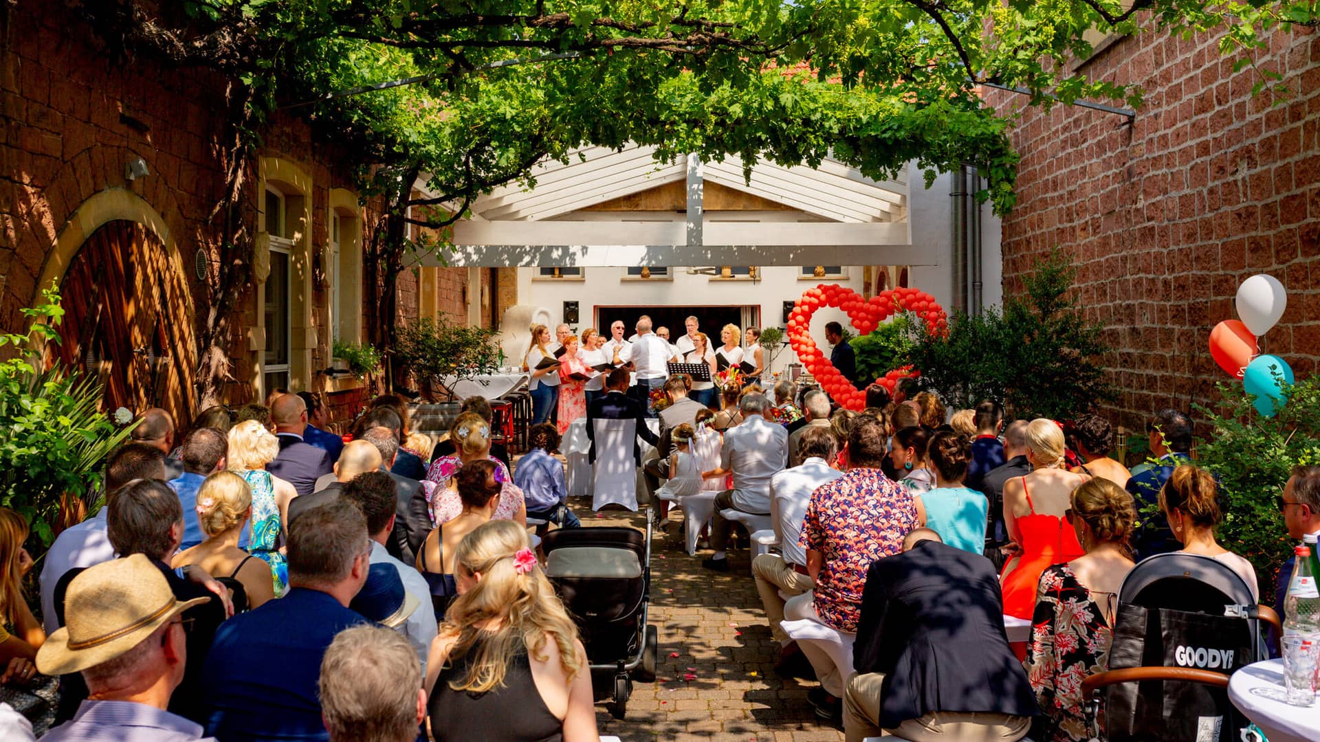 Jennifer Gregor Hochzeitsfotograf Rebe Deidesheim Location 06 Hochzeitspaar Bei Tisch Unter Freiem Himmel.Dq39AnH3 Jennifer und Gregor beim Brautpaarshooting am Tisch im Freien – Rebe Deidesheim