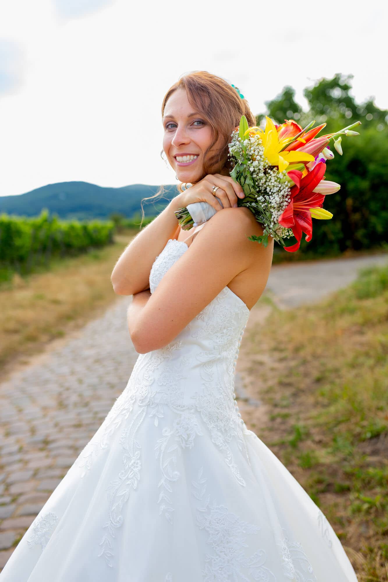 Jennifer Gregor Hochzeitsfotograf Rebe Deidesheim Location 29 Bride In White Dress Holding Bouquet.BAhgxWmT Braut Jennifer mit Blumenstrauß im Weinberg bei Deidesheim – Hochzeitsfotografie Pfalz