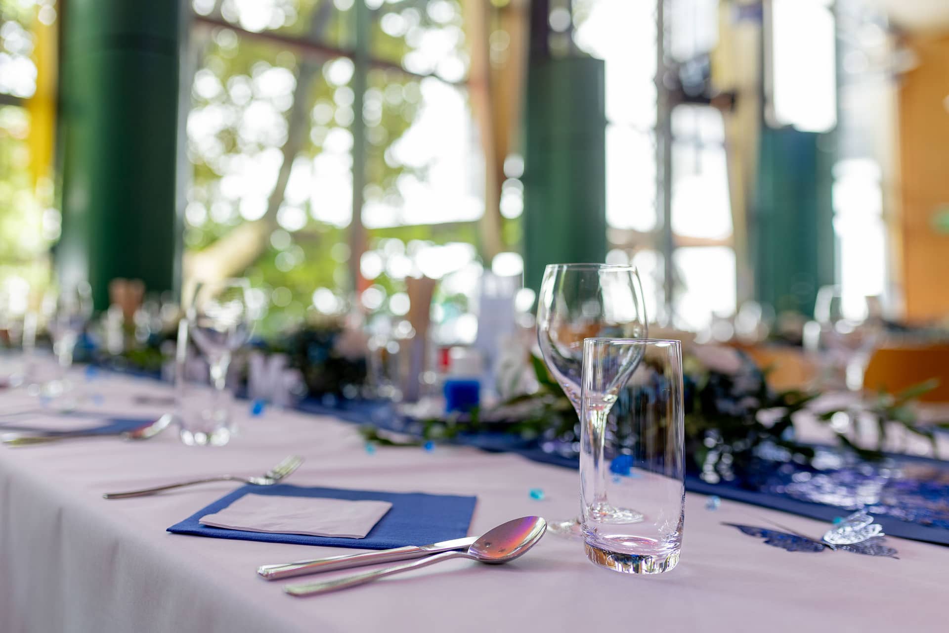 Julia Dennis Hochzeit Mannheim Gemeindesaal St Nikolaus Mannheim 4k8a5131.M0PpOok0 Aufgedeckter Tisch mit blauer Dekoration im Gemeindesaal St. Nikolaus Mannheim