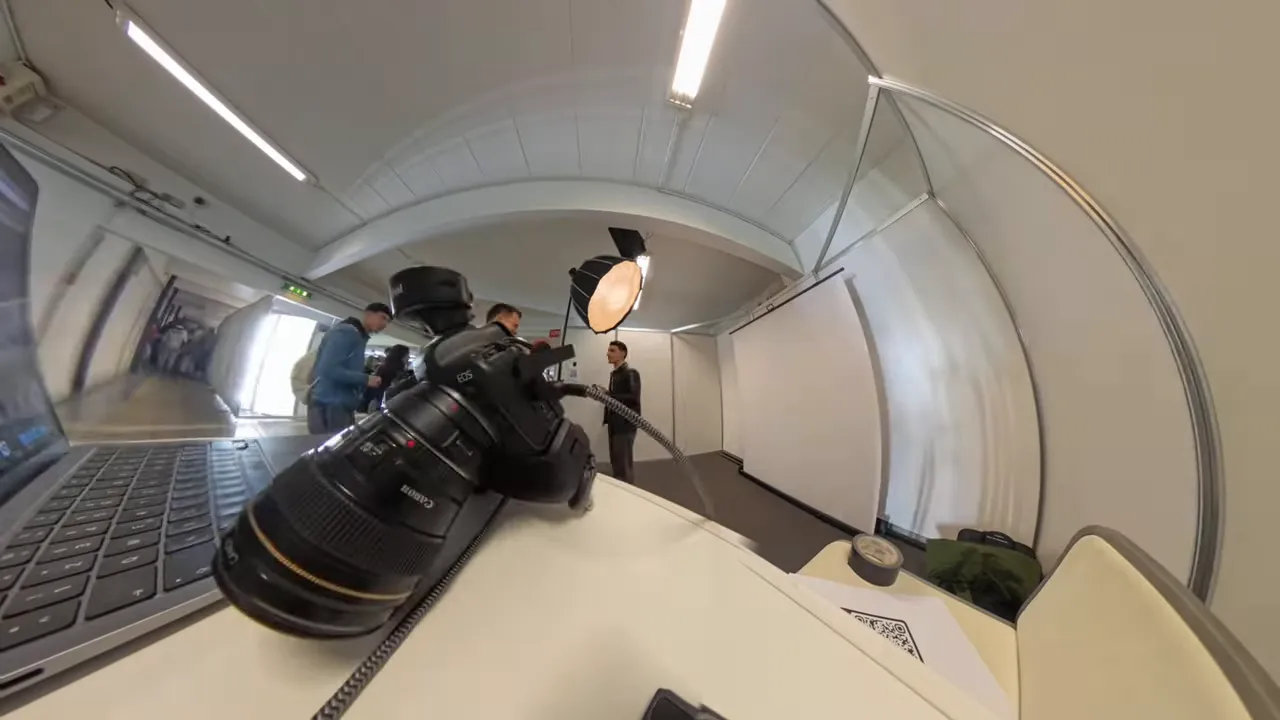 Kamera liegt mit angeschlossenem Kabel neben einem Laptop, Studio-Hintergrund sichtbar