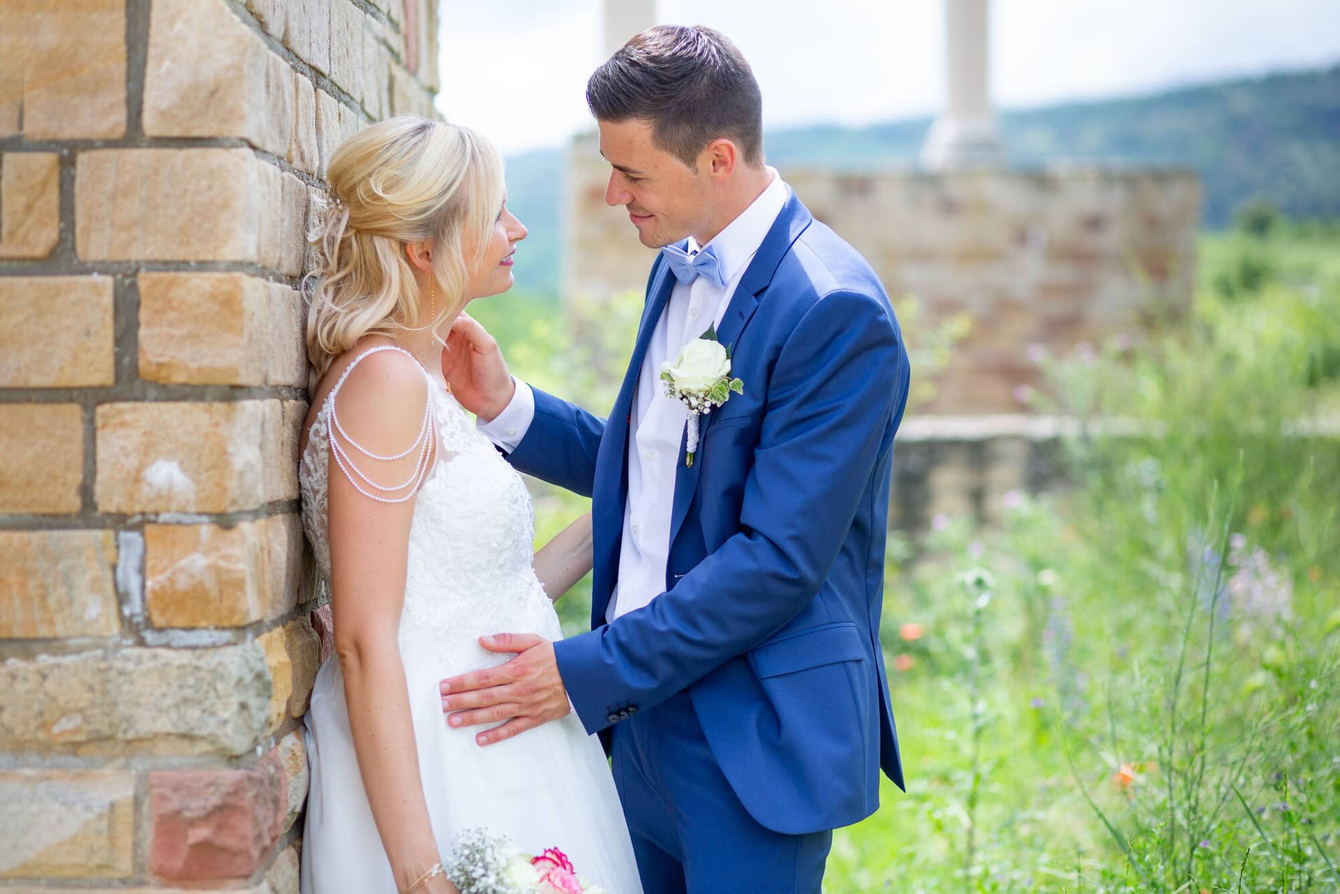 Liane Kevin Hochzeitsfotograf Schlosspavillon Kleinniedesheim Brautpaarshooting 06 Eine Joviale Hochzeitspaar Steht Vor Einem.CkgHpM9Z Liane und Kevin lachen vor einer historischen Steinmauer – Brautpaarshooting Pfalz
