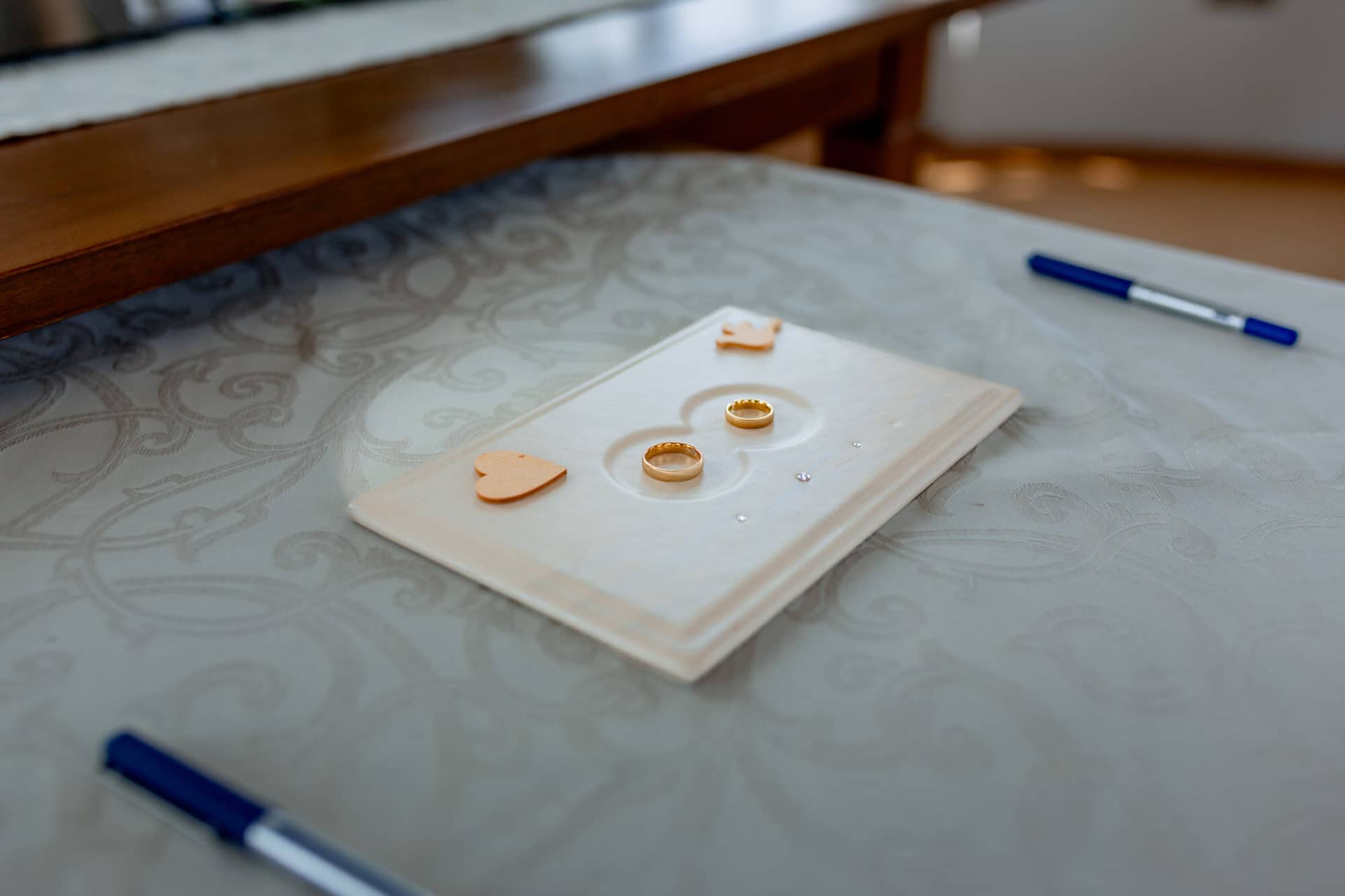 Liane Kevin Hochzeitsfotograf Schlosspavillon Kleinniedesheim Location 02 Hochzeitsschein Auf Tisch.BlNpISVS Heiratsurkunde und Ringe auf dem Tisch im Schlosspavillon Kleinniedesheim