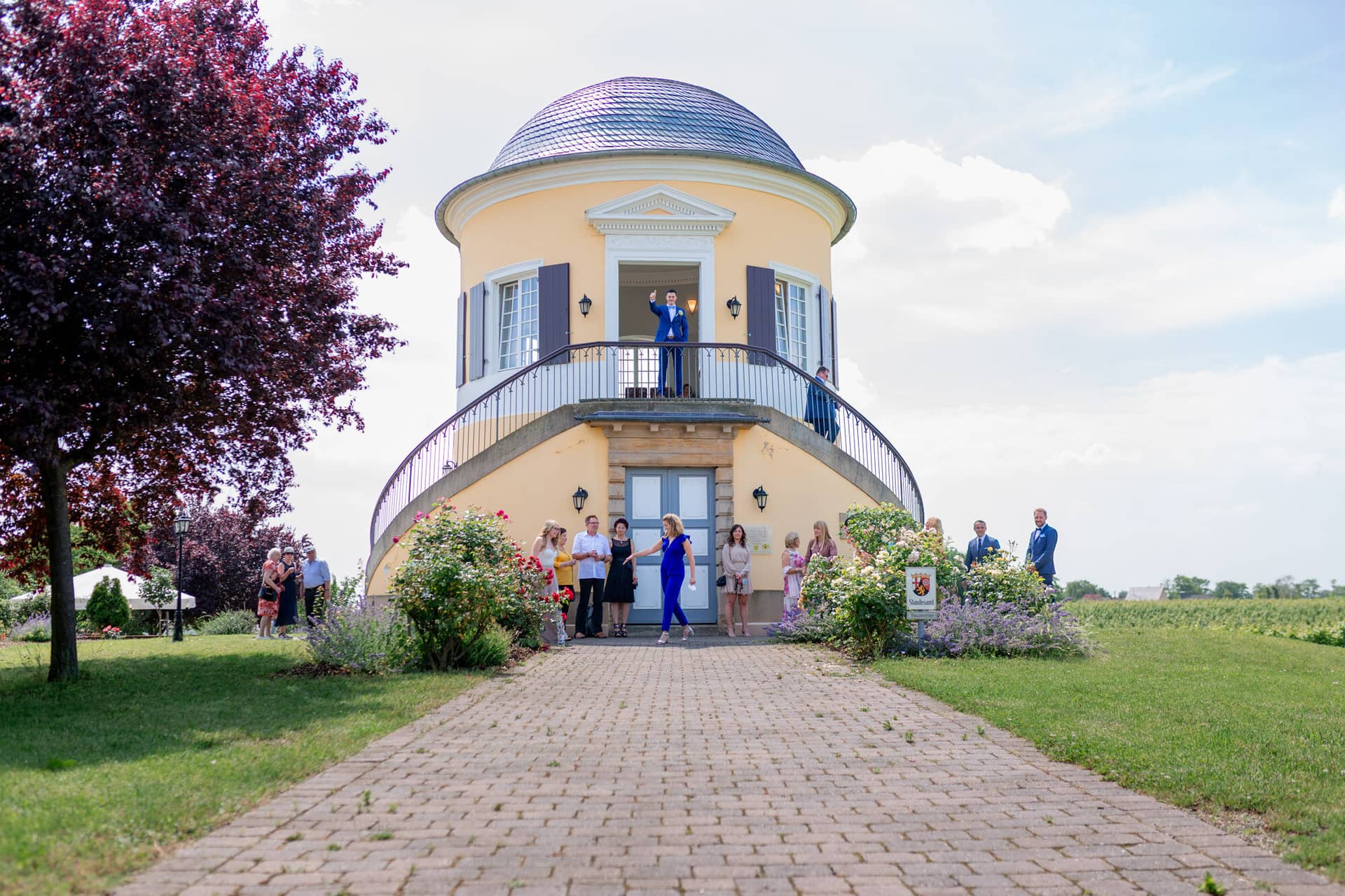Liane Kevin Hochzeitsfotograf Schlosspavillon Kleinniedesheim Location 05 In Diesem Bild Zeigt Es Ein.K6kqp1iA Außenansicht des Schlosspavillon Kleinniedesheim mit Brautpaar und Hochzeitsgesellschaft